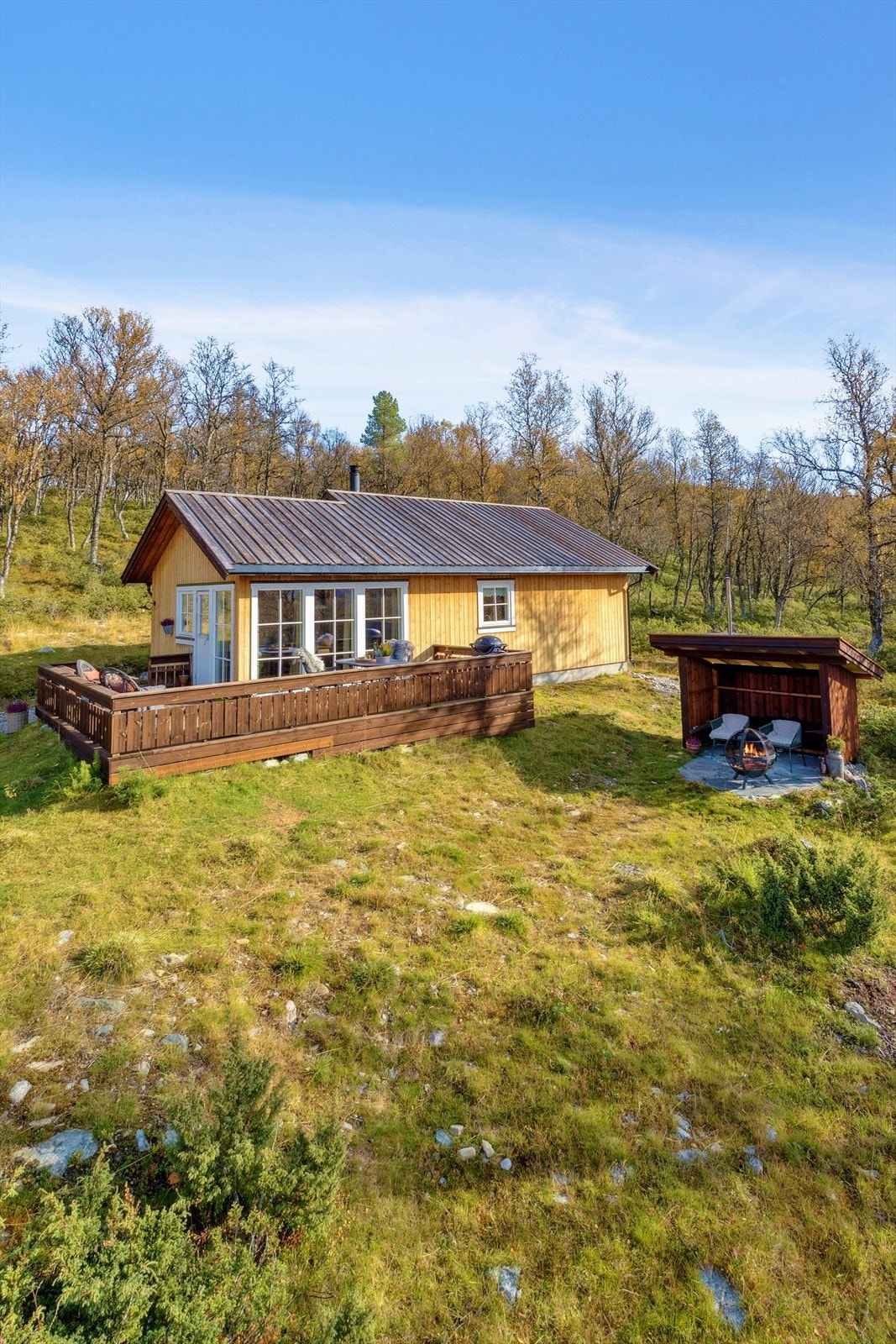 Eiendommen har en stor veranda, gapahuk og vedskjul, og er omkranset av fjellbjørkeskog. Galleribilde