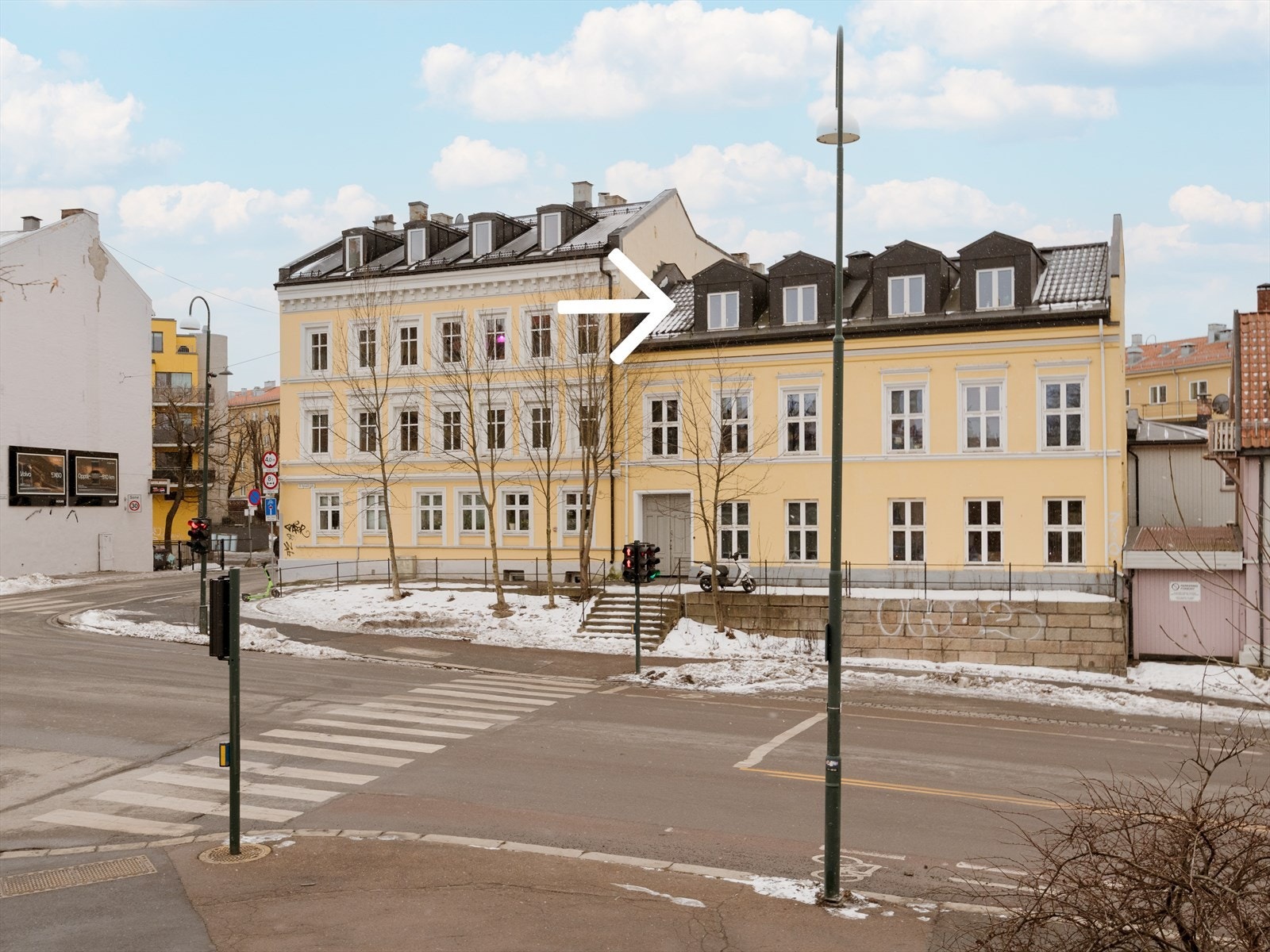 Her bor du i en klassisk bygård fra 1892. Leiligheten er til høyre for den hvite pilen, vist på bildet. Galleribilde