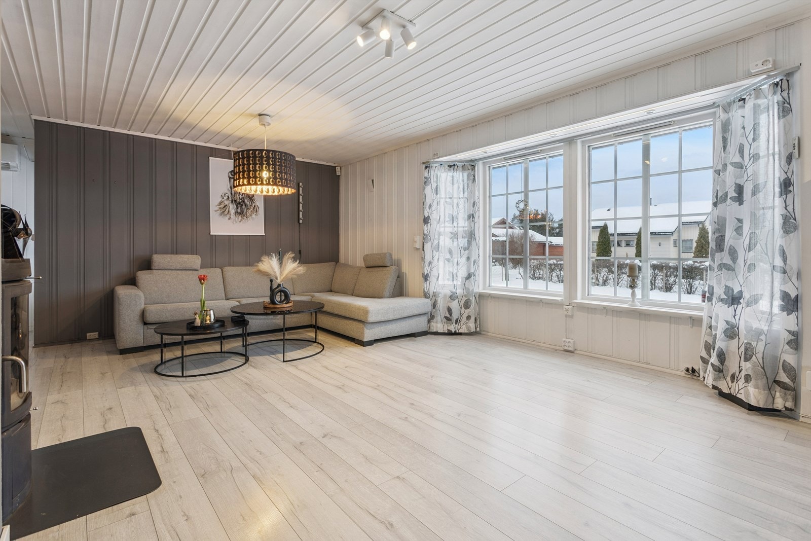 Store vindusflater gir rikelig med naturlig lys inn i oppholdsrommet, som har et tidsmessig fargevalg. Galleribilde