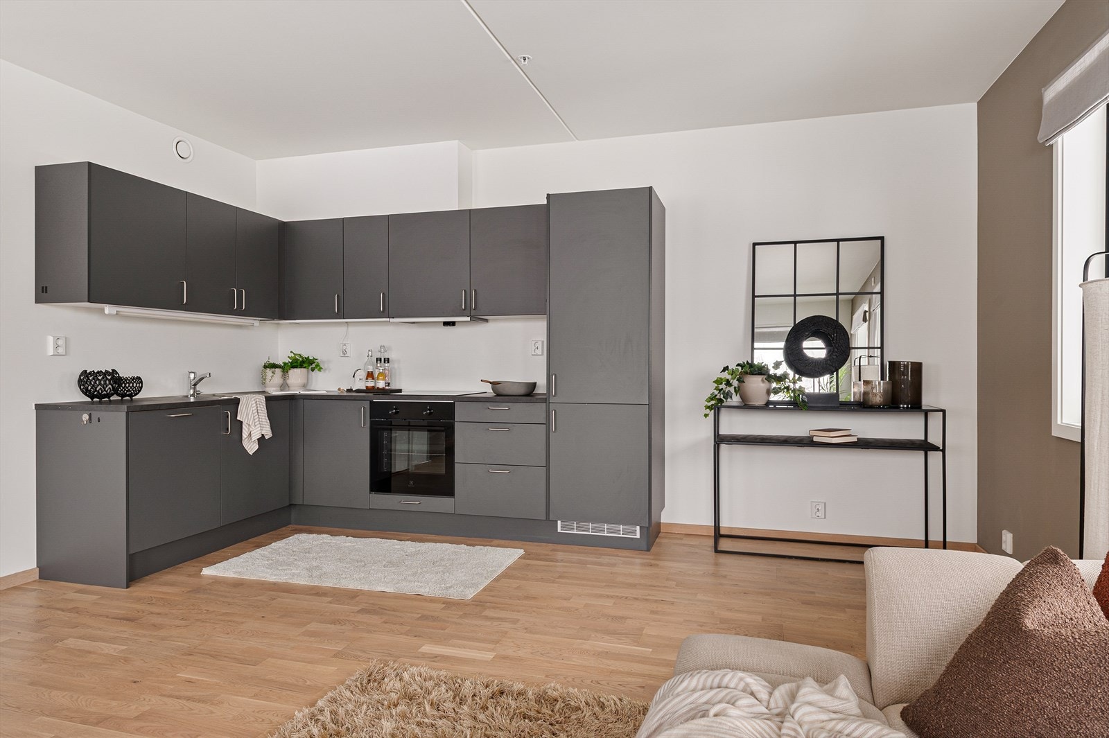 Kjøkkeninnredningen har mørke, slette fronter og laminat benkeplate. Galleribilde