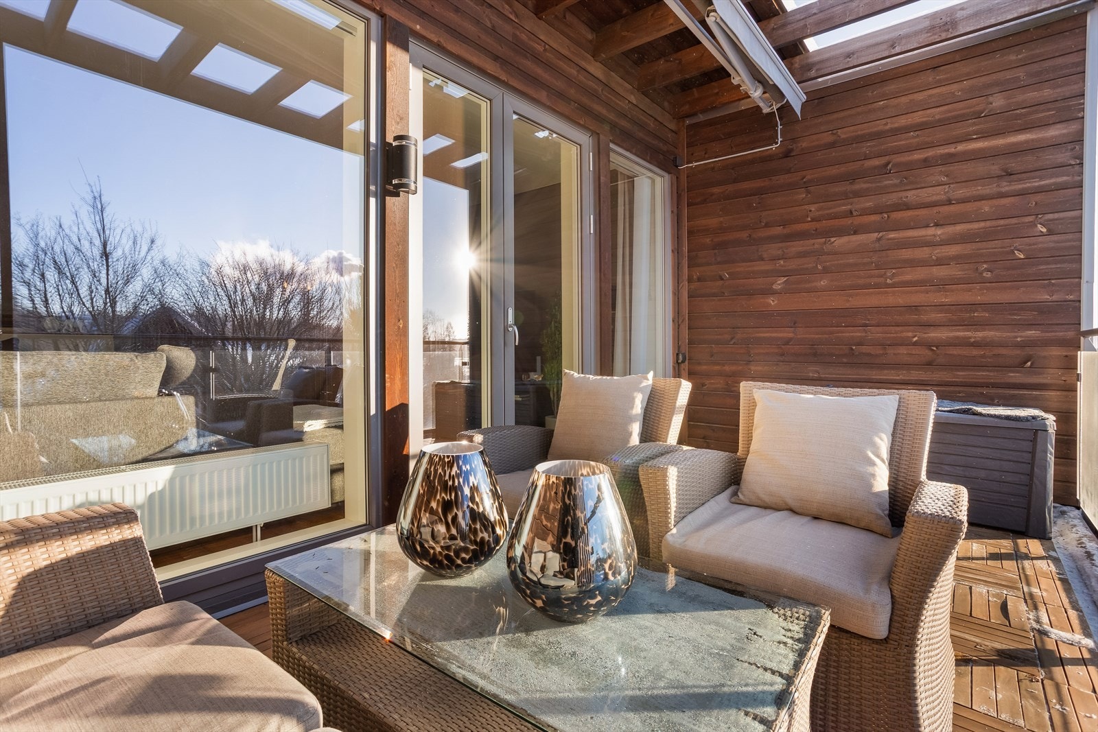 Tredekket på gulvet gir en lun og behagelig følelse på uteplassen. Galleribilde