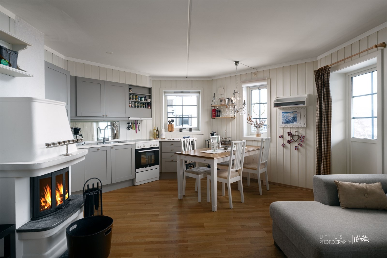 Nærheten til peis skaper en koselig og praktisk stue- og kjøkkensone Galleribilde