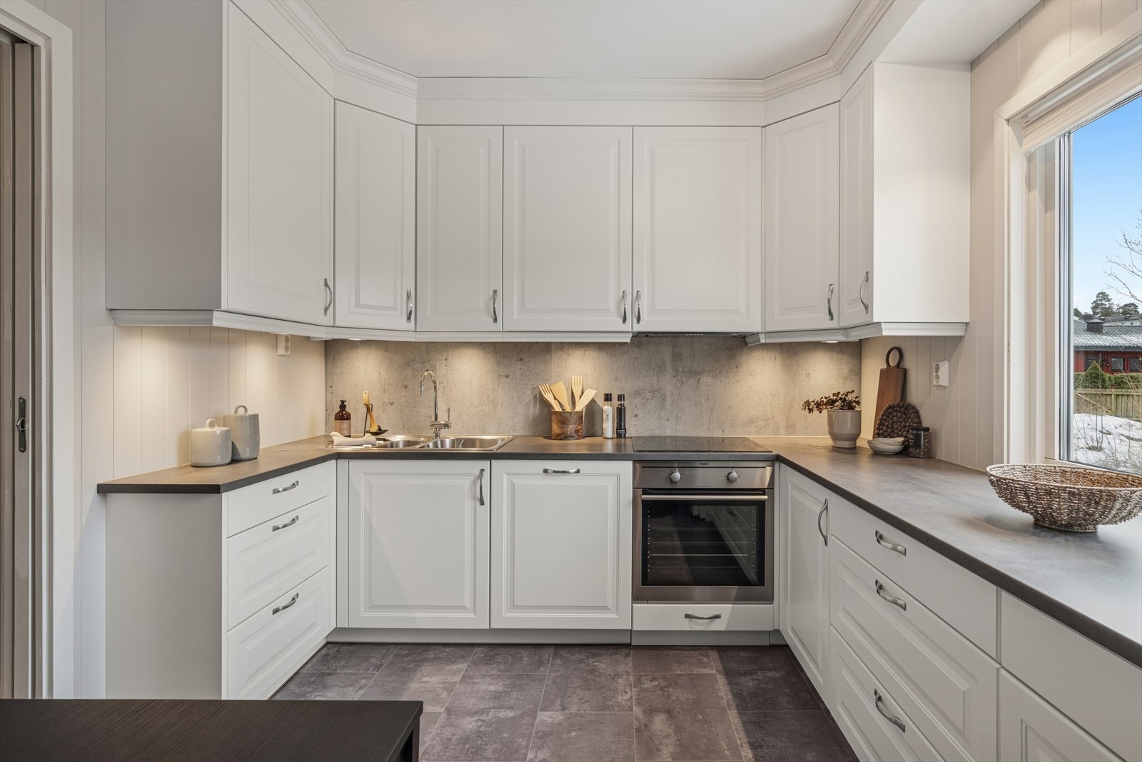 På veggen bak vasken og platetoppen er det montert kjøkkenplater som gjør rengjøring etter matlaging til en lek. Det er installert automatisk vannstoppesystem. Galleribilde