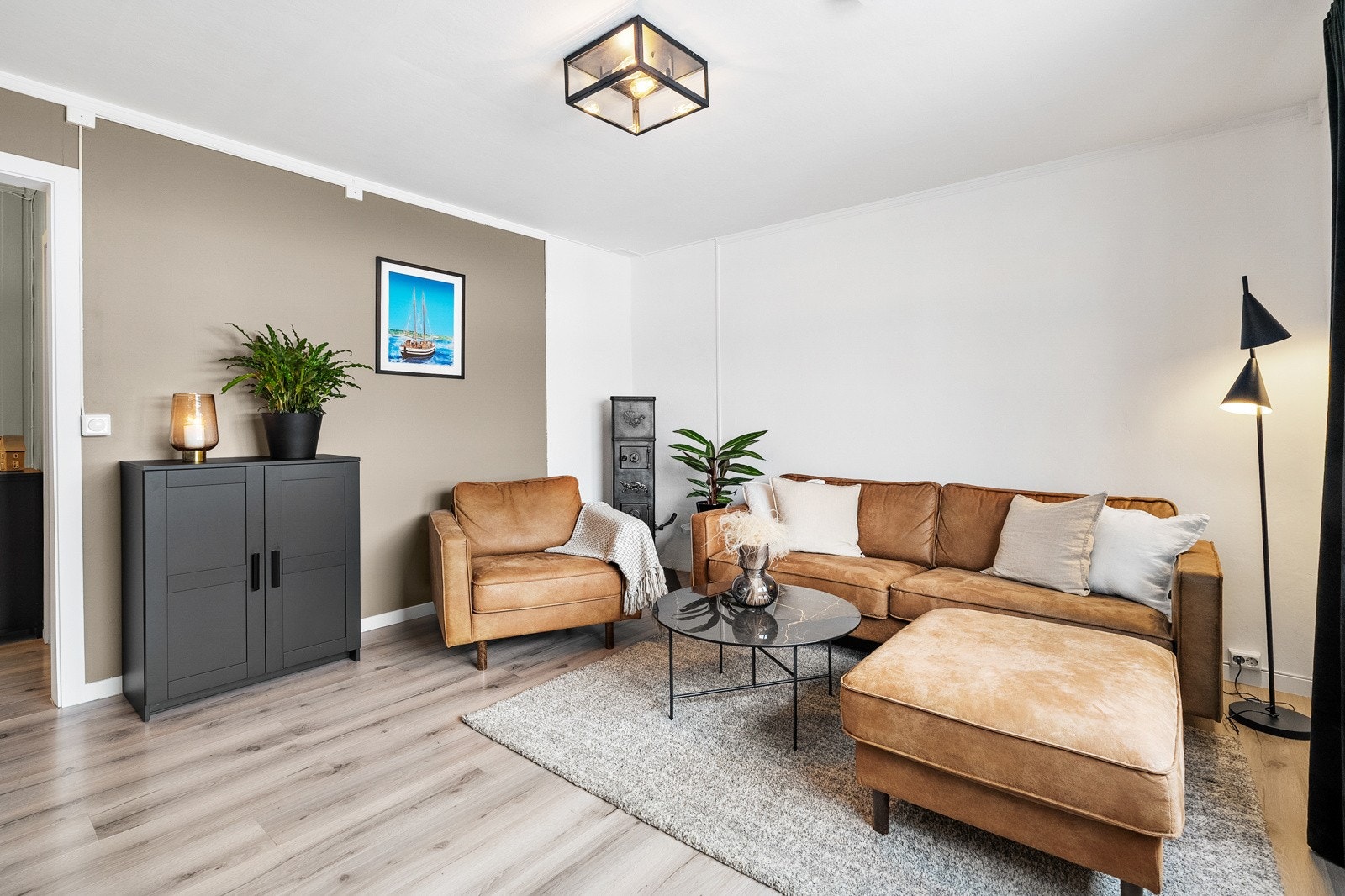 Stuen har en sjarmerende vedovn i det ene hjørnet samt plass til sofagruppe. Galleribilde