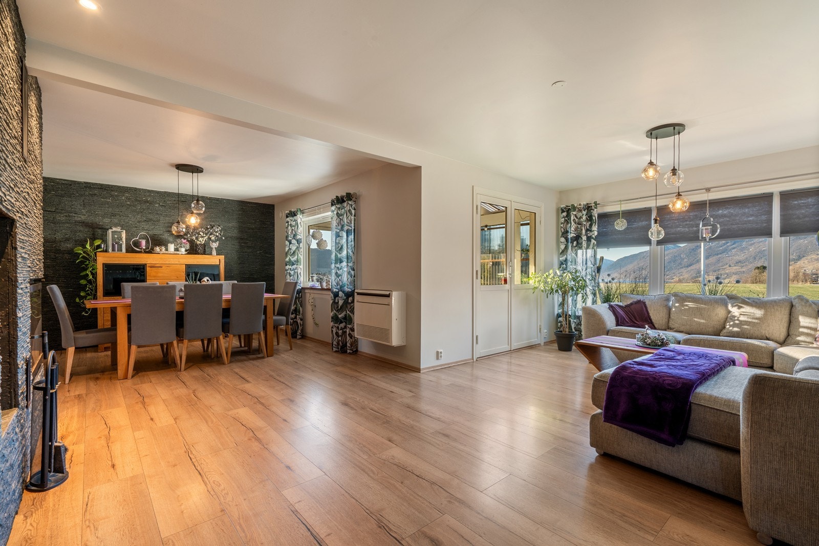 Stuen er svært romslig og fremstår som lys og luftig med flere store vindusflater som slipper inn rikelig med naturlig lys og gir flott utsikt mot vakre naturomgivelser. Galleribilde