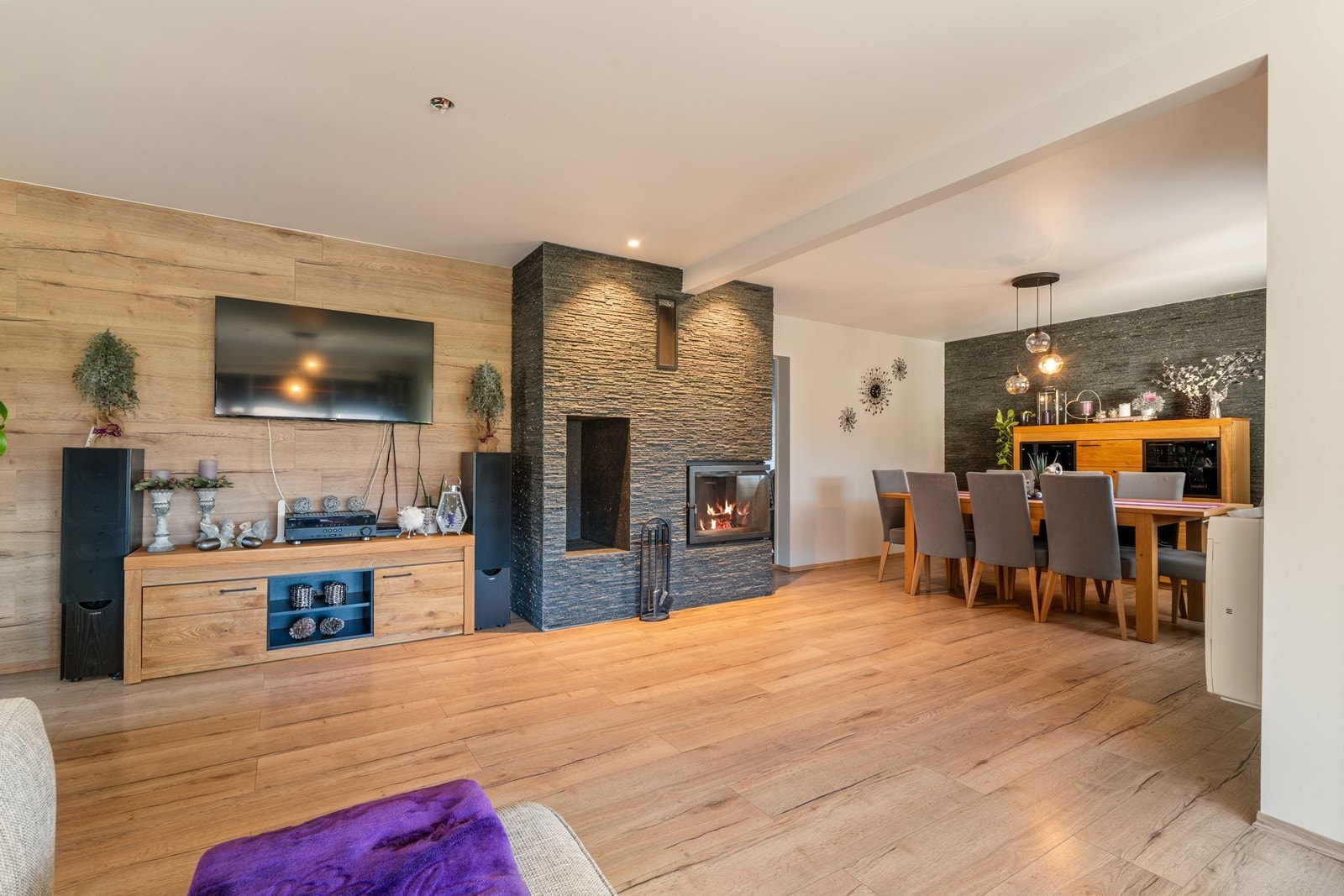 Midt i rommet er det plassert en vakker peis som binder de ulike sonene naturlig sammen og samtidig fungerer som et møblerende element. Galleribilde