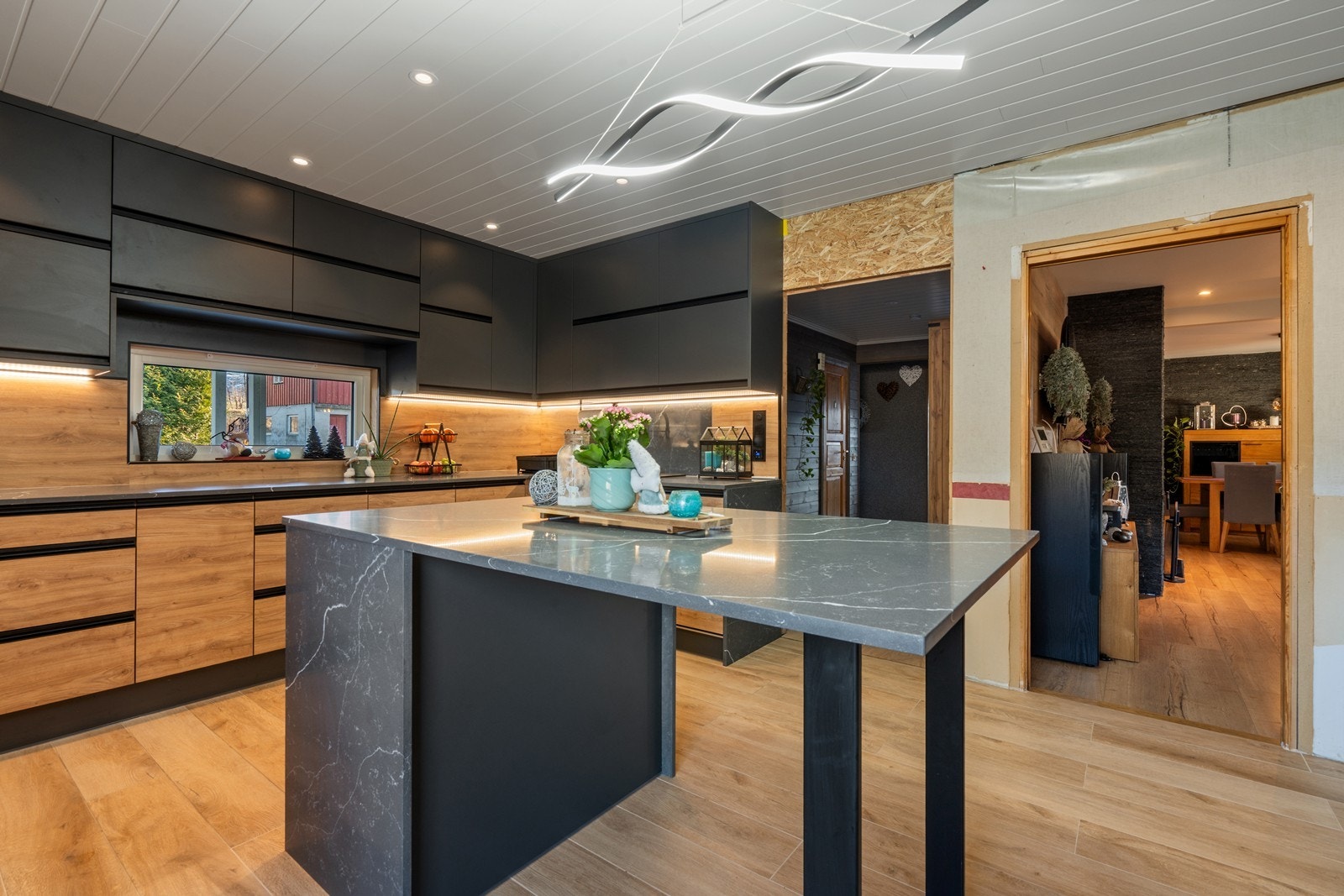 En praktisk kjøkkenøy midt i rommet byr på rikelig med oppbevaringsplass, god benkeplass og fungerer som et uformelt og hyggelig spisested. Galleribilde