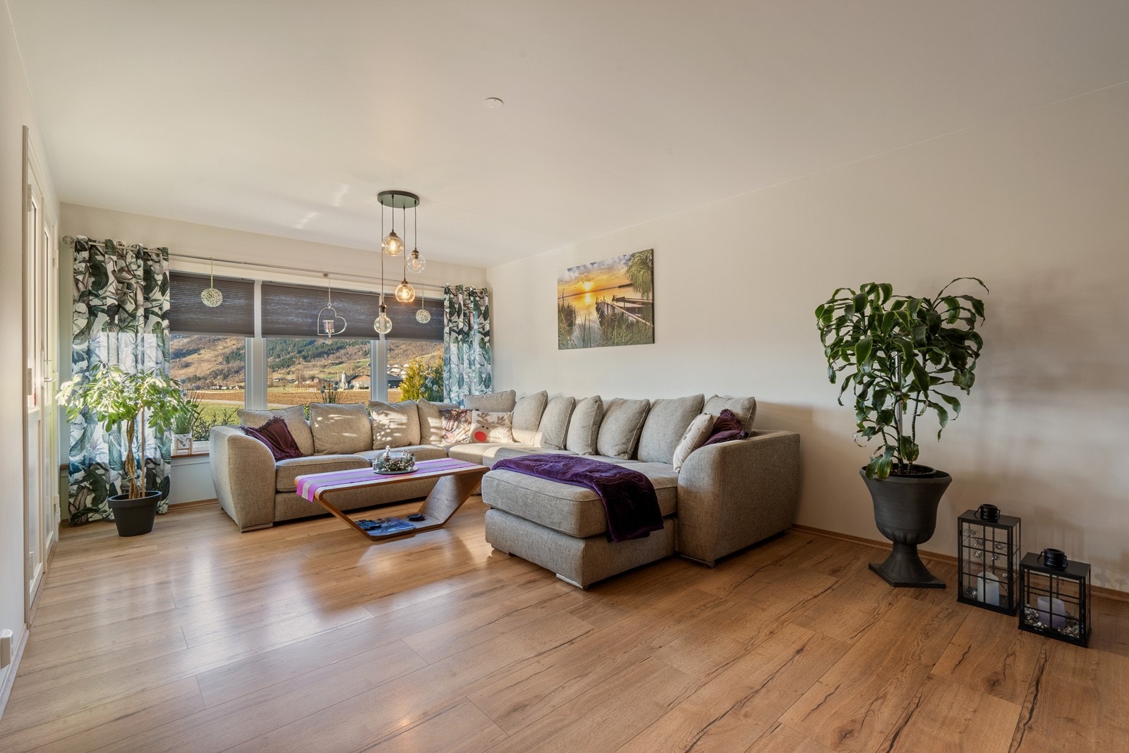 Med tydelig soneinndeling fremstår rommet som både funksjonelt og innbydende, med en hyggelig sofakrok som gir gode muligheter for både avslapning og sosialt samvær. Galleribilde