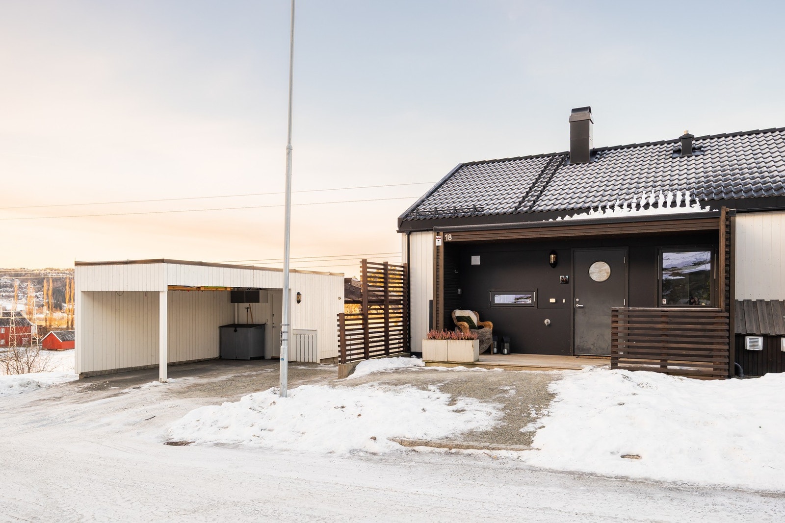 Like ved inngangspartiet er en romslig carport med tilhørende bod på 5,5 kvm. Galleribilde