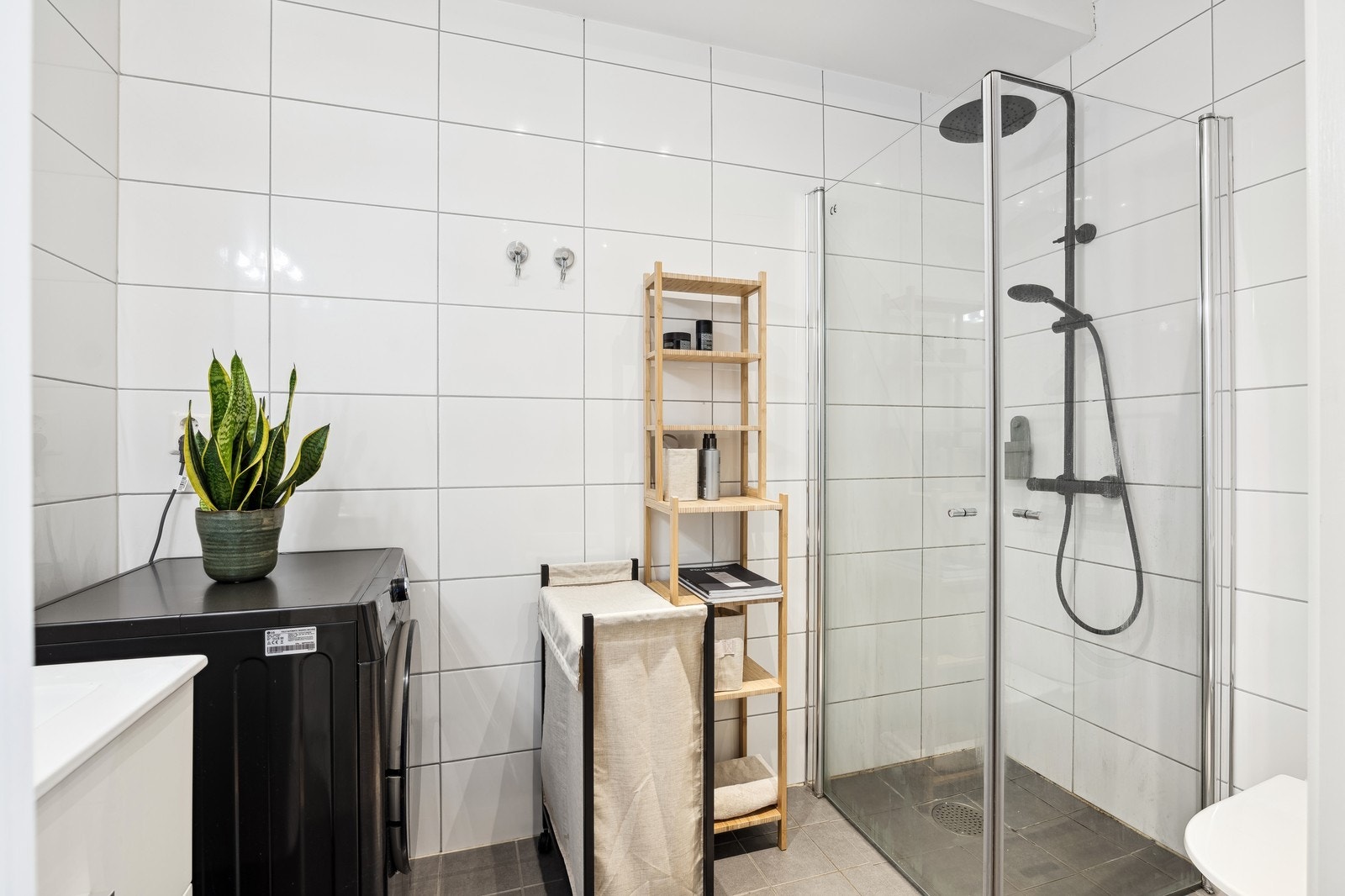 Pent flislagt bad med hjørnedusj, toalett og servant m/innredning. Vaskemaskin følger med Galleribilde