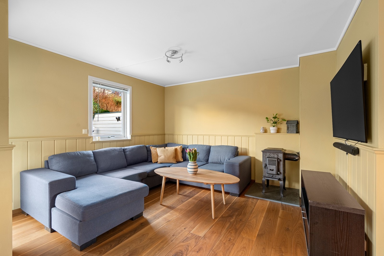 Trivelig stuerom med parkett på gulv og malte flater på vegger.
Vedovn for kalde dager. Galleribilde