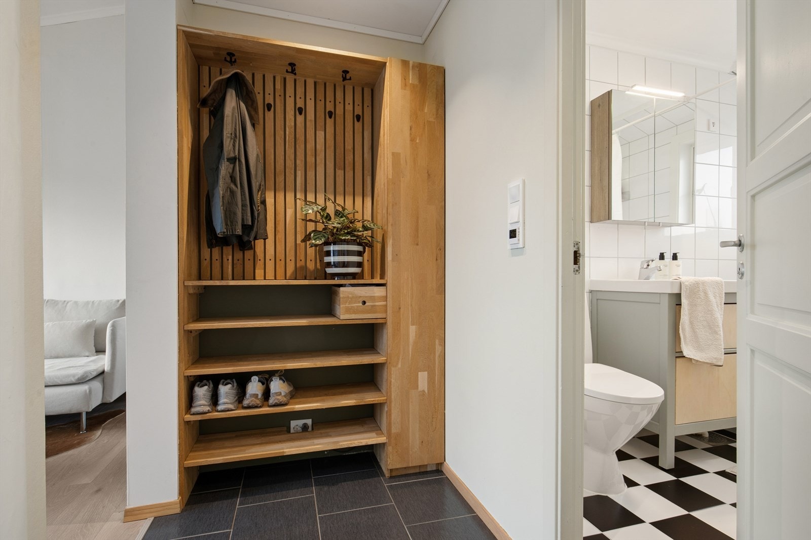 Velkommen inn til en lys og praktisk entré med fliser og smart oppbevaringsløsning. Galleribilde