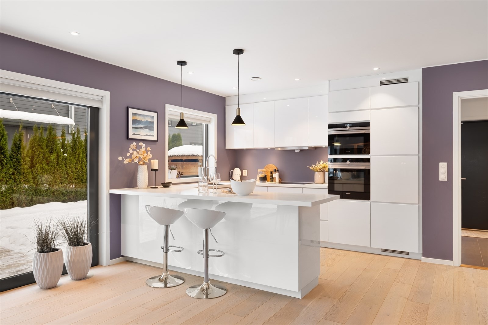 Kjøkkenet ligger i åpen løsning mot stuen og er praktisk utformet med innredning langs to vegger samt utstikker med plass til barstoler. Galleribilde