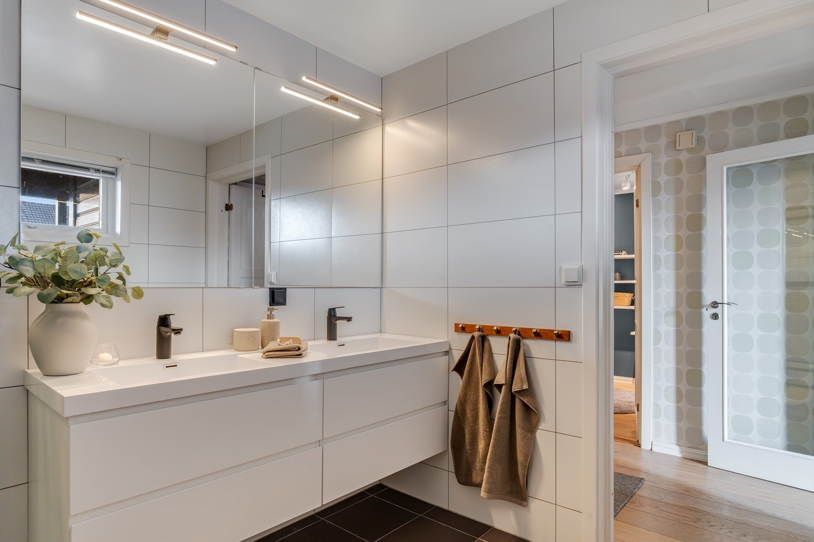 Badet inneholder dobbelservant i møblement, speilskap m/belysning, toalett og dusjkabinett. Galleribilde