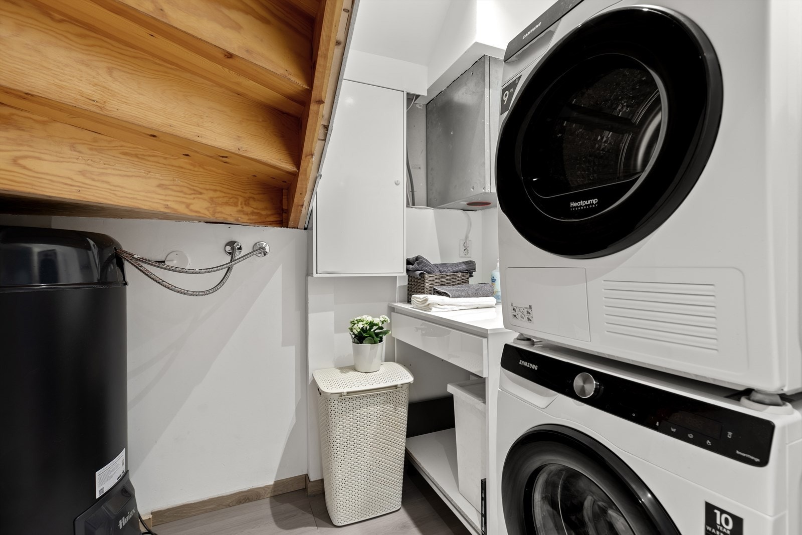 Praktisk teknisk rom under trappen med opplegg for vaskemaskin og tørketrommel. Galleribilde