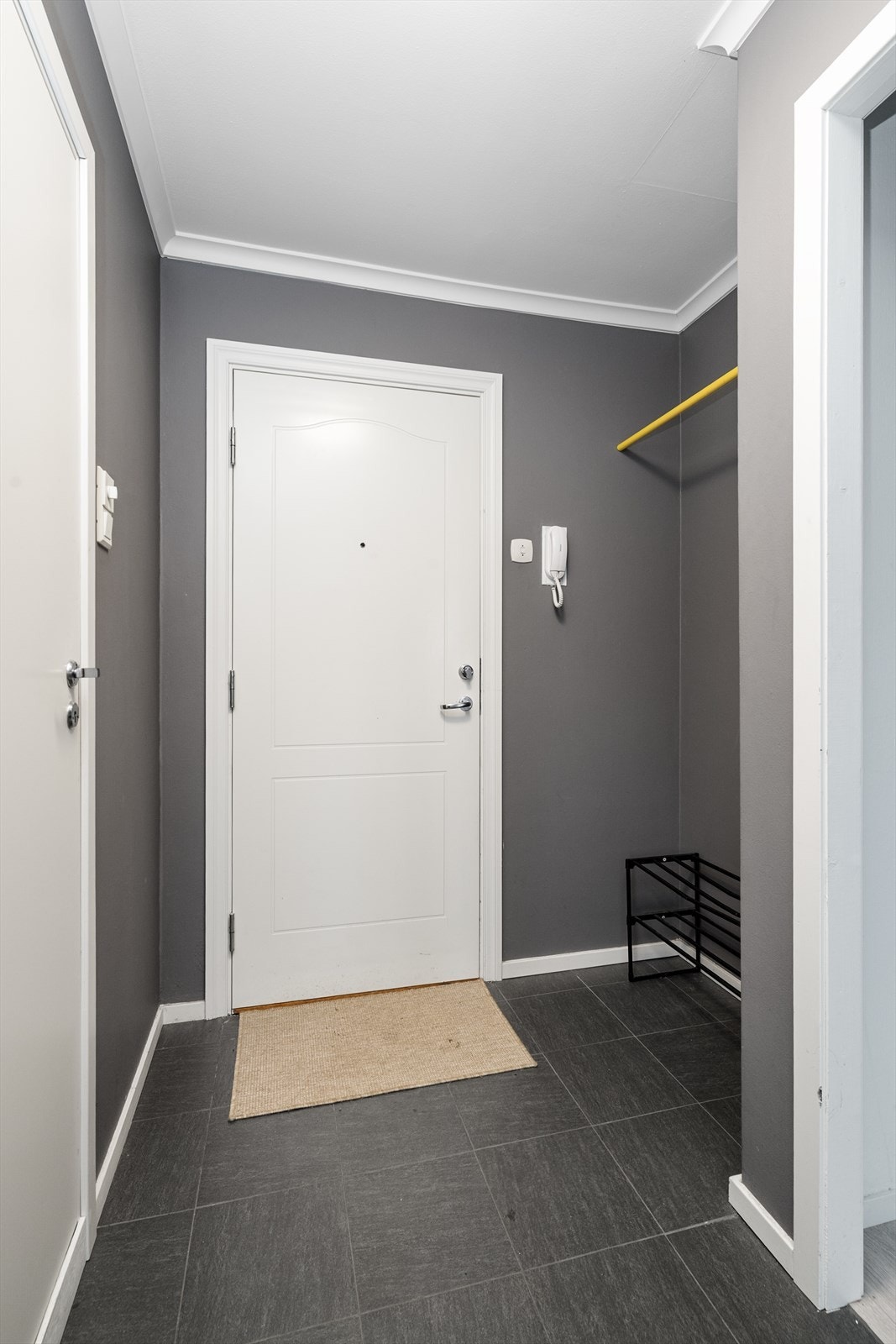 Fin og romslig entré med flislagt gulv og nisje for oppbevaring av sko- og yttertøy. Praktisk porttelefon, som gjør det enkelt å slippe inn besøkende. Galleribilde