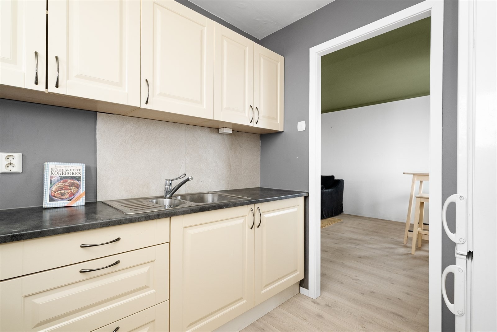 Laminat benkeplate med god arbeidsflate, nedfelt platetopp og benkebeslag i rustfritt stål. Det er avsatt plass til frittstående kjøl/fryseskap. Galleribilde