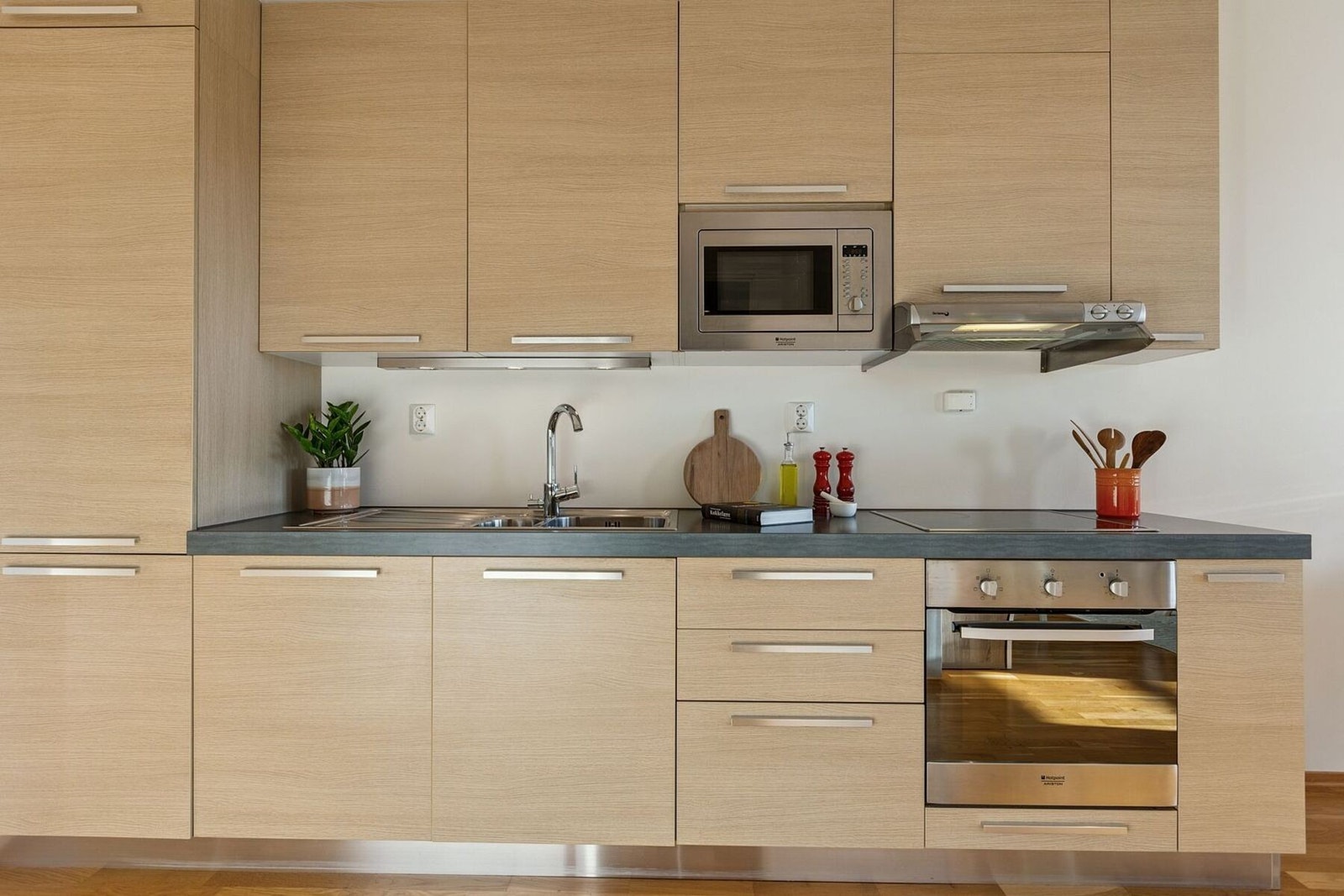 Pent kjøkken med integrerte hvitevarer. Det er byttet til induksjonstopp på kjøkkenet i desember 2025. Galleribilde