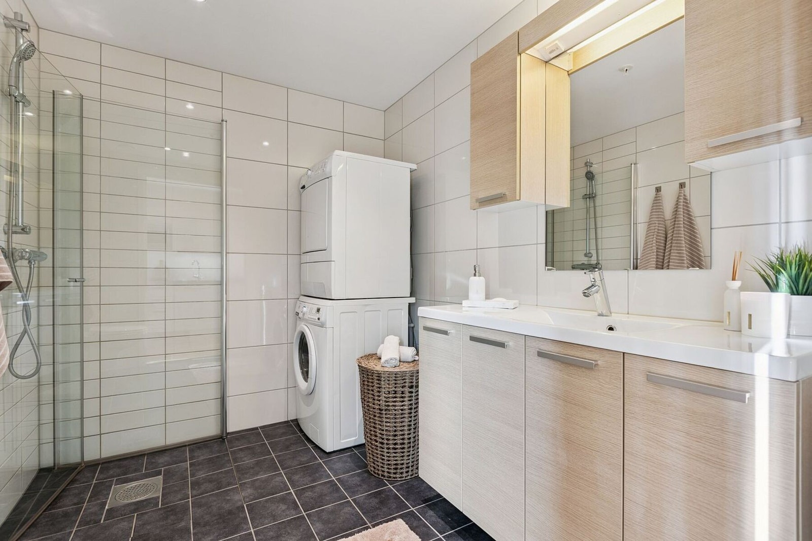 Flislagt baderom som måler gode 5 kvadratmeter med opplegg til vaskemaskin og tørketrommel. Galleribilde