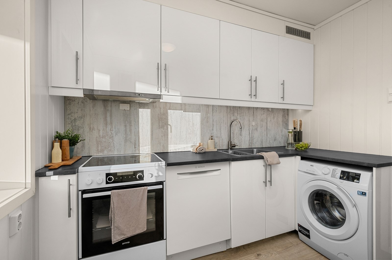 Innredning med benkebereder, mekanisk avtrekksvifte over stekesonen, opplegg for vaskemaskin og opplegg for oppvaskmaskin. Vaskemaskinen medfølger IKKE handelen. Galleribilde