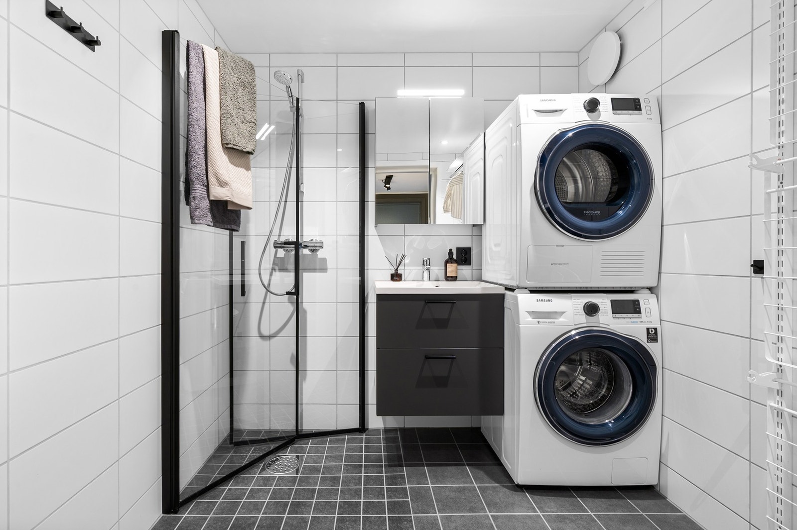 Lyst og lekkert flislagt bad i 1.etasje med dusjhjørne, servant på underskap, veggmontert WC og speilskap. Galleribilde