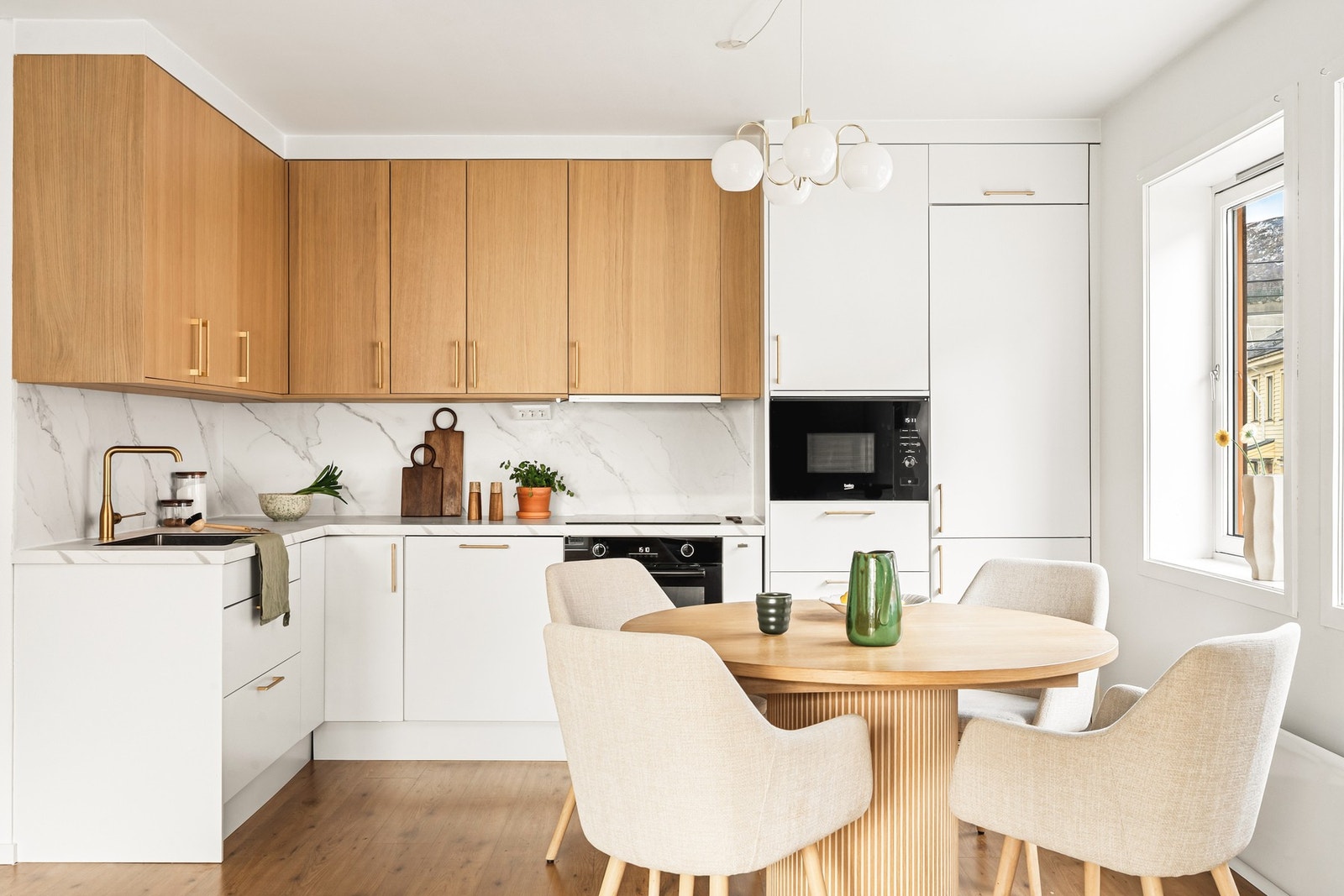 Flott Epoq-kjøkken fra 2024 med moderne uttrykk, slette hvite fronter og overskap i lys treutførelse. Galleribilde