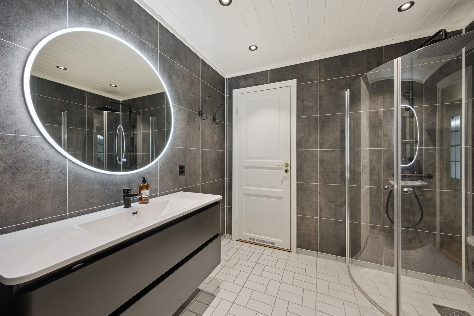 Badet er innredet med nedfelt servant, toalett og dusjhjørne Galleribilde