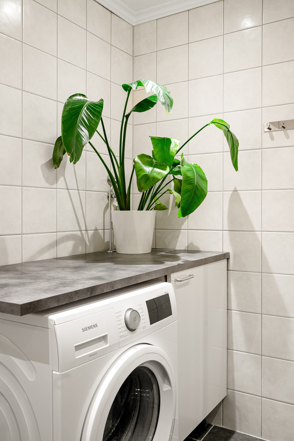 Smart nisje på badet med opplegg for vaskemaskin. Varmtvannstank plassert i benk. Galleribilde