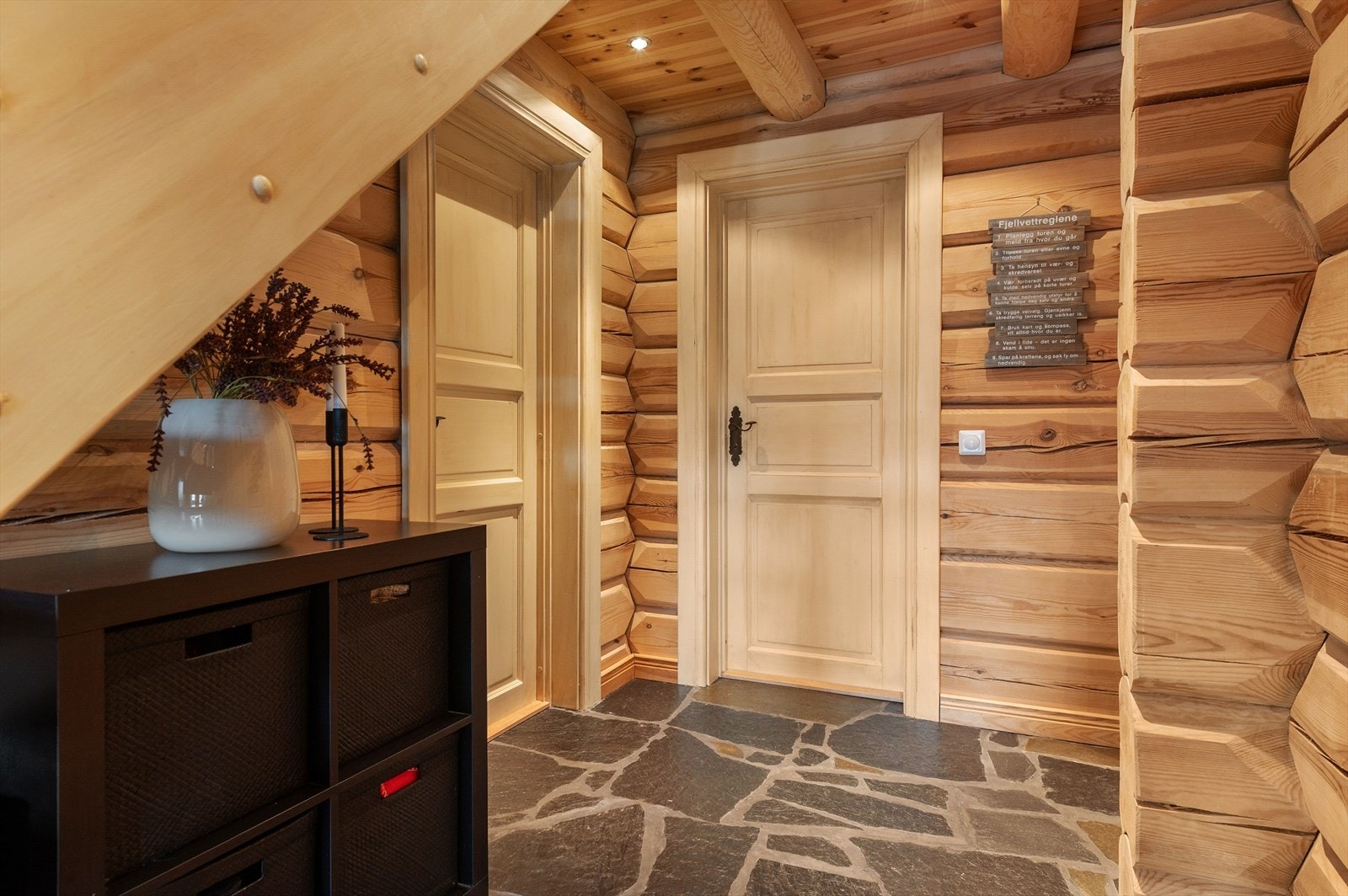 Flislagt gulv gir en robust og enkel rengjøringsløsning i entréen. Tømmervegger og takbjelker skaper et solid og naturlig utseende. Galleribilde