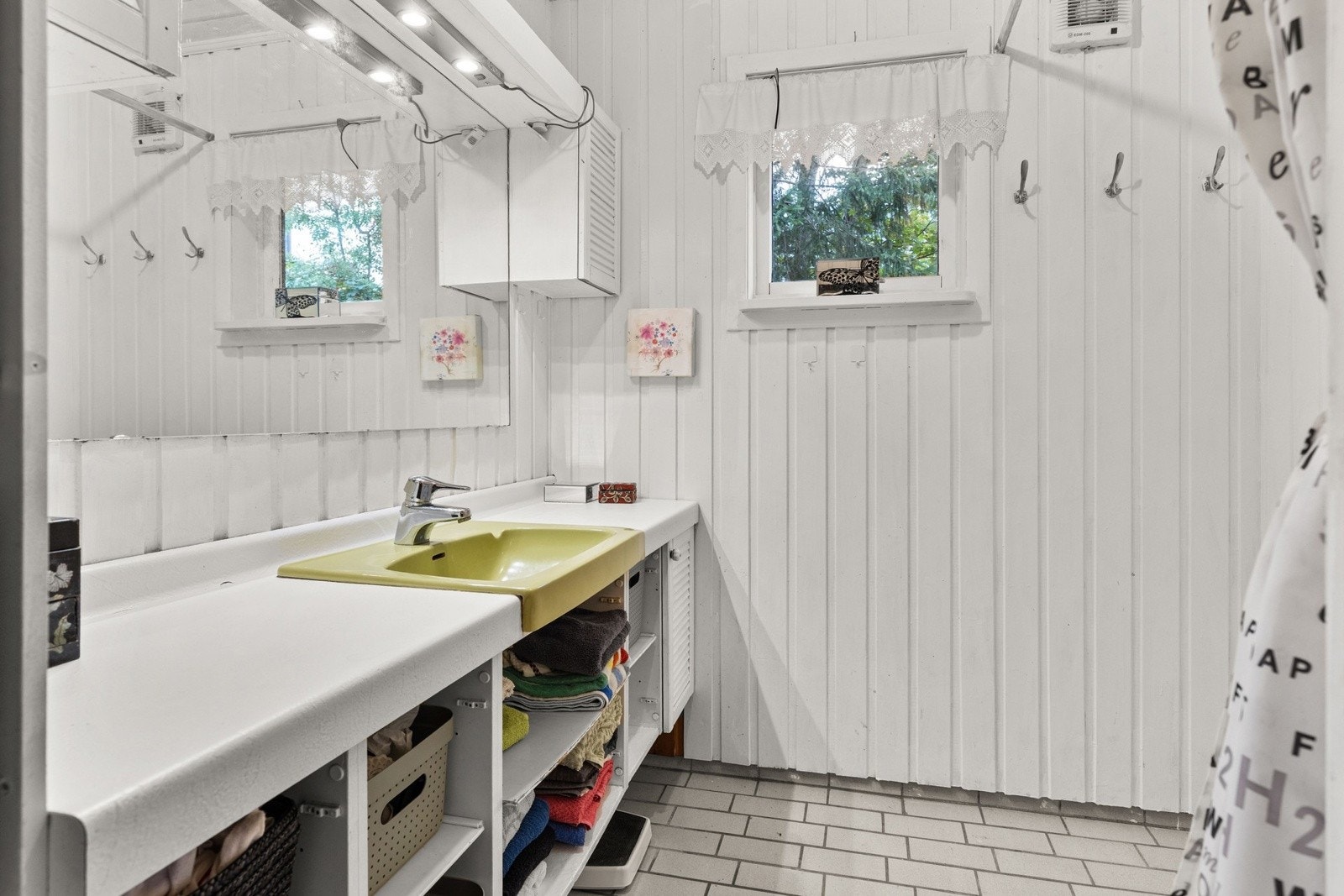 Boligen har et eldre bad med dusj og servant i innredning. Galleribilde