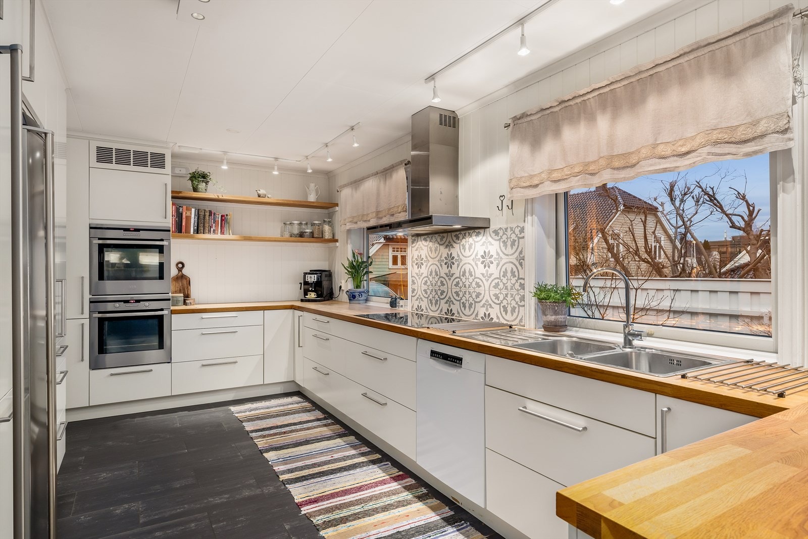 Kjøkkenet er utstyrt med integrerte hvitevarer og har rikelig med benkeplass. Galleribilde