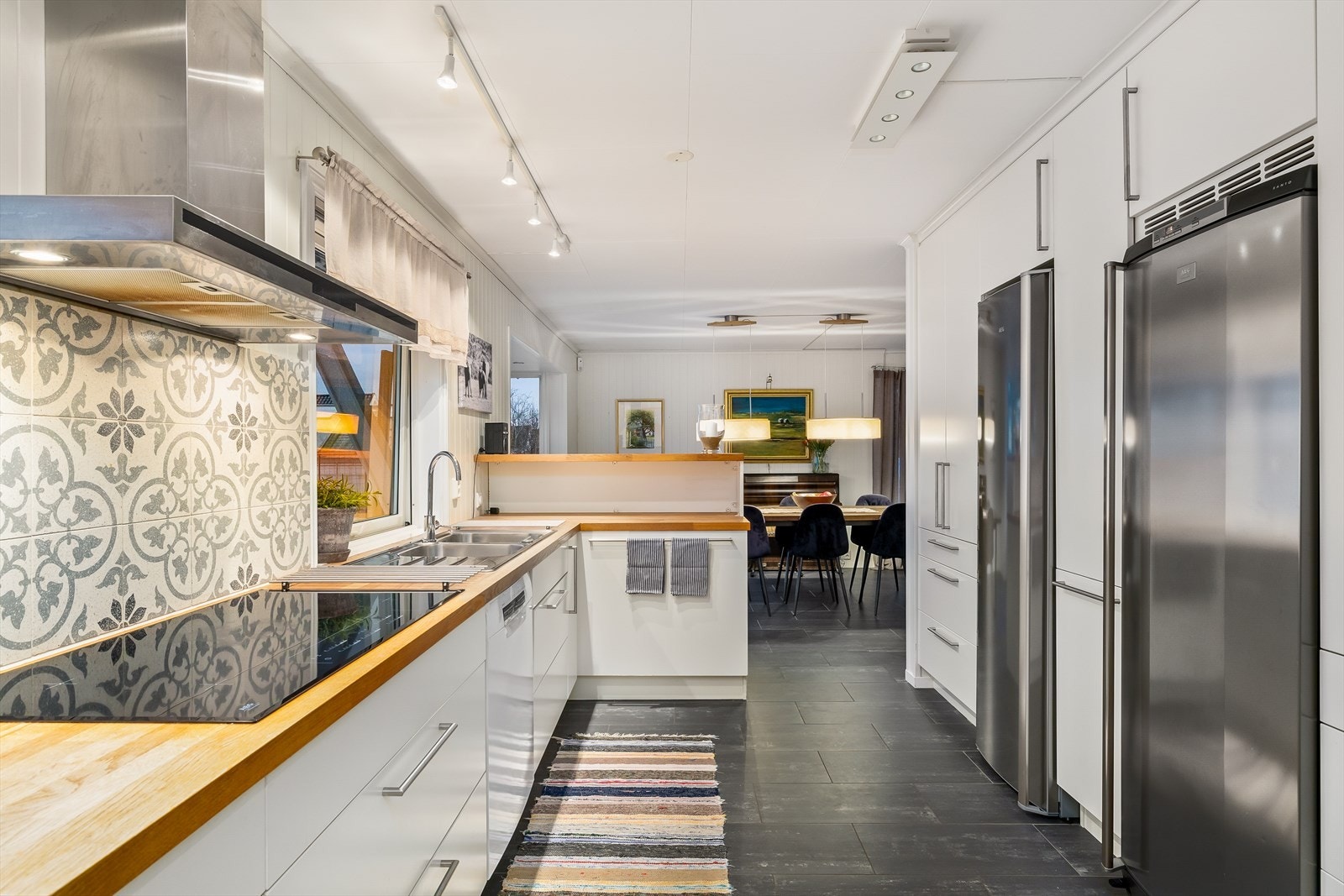 Kjøkkenet ligger i naturlig tilknytning til spisestuen, noe som gir en sosial og praktisk løsning med enkel kontakt mellom rommene. Galleribilde