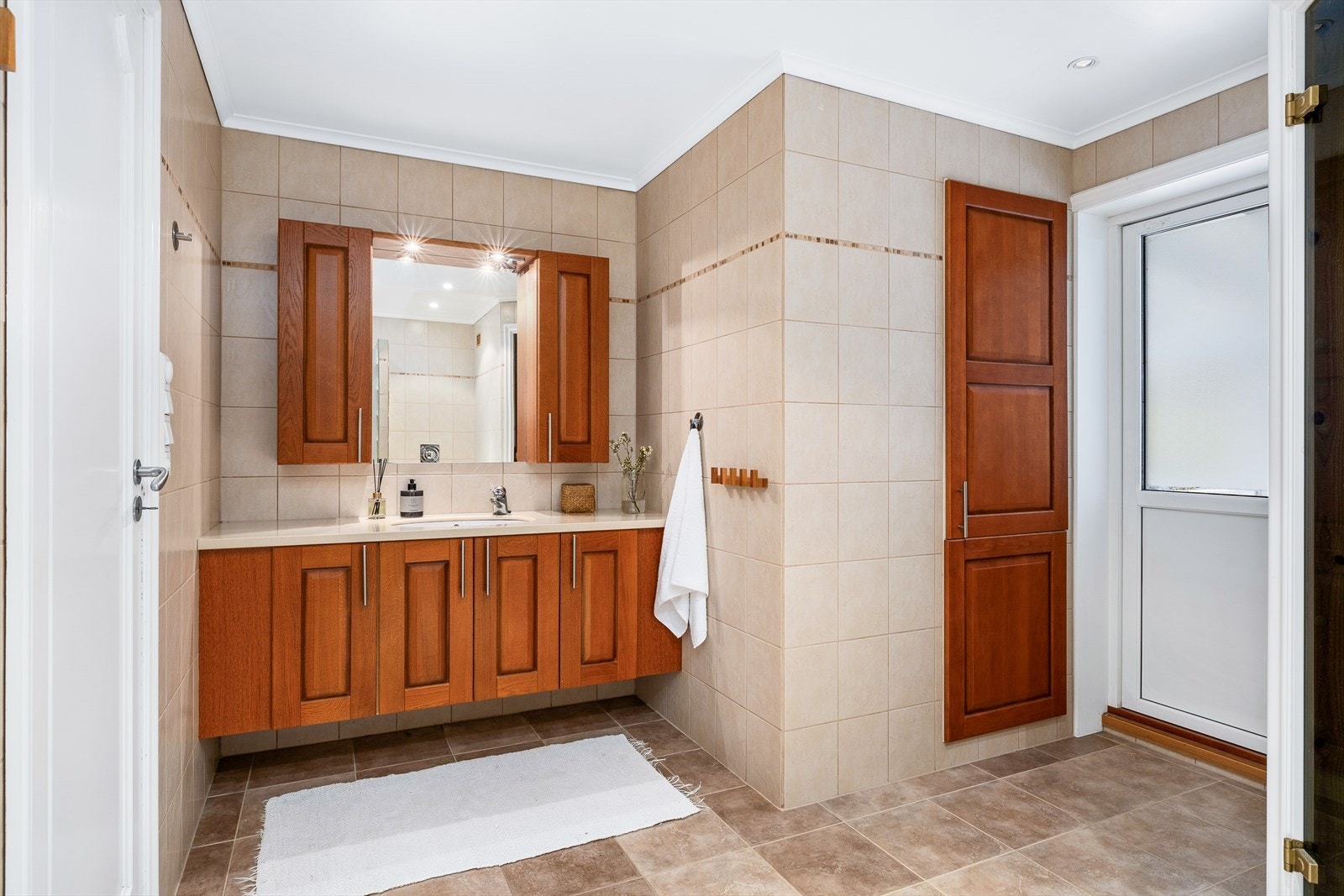 Delikat og lyst bad med behagelig gulvvarme, downlights i himling og romslig servant med innredning og speil. Galleribilde