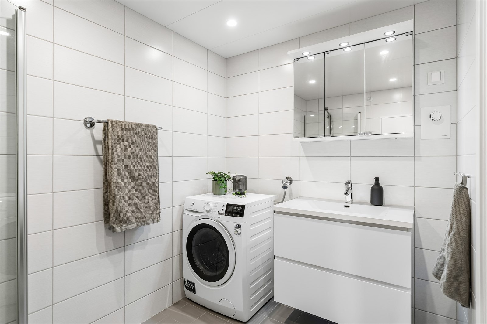 Rommet har innredning bestående av skap med glatte fronter og servant. I tillegg er det utstyrt med gulvstående klosett, dusj på gulv og opplegg for vaskemaskin. Galleribilde