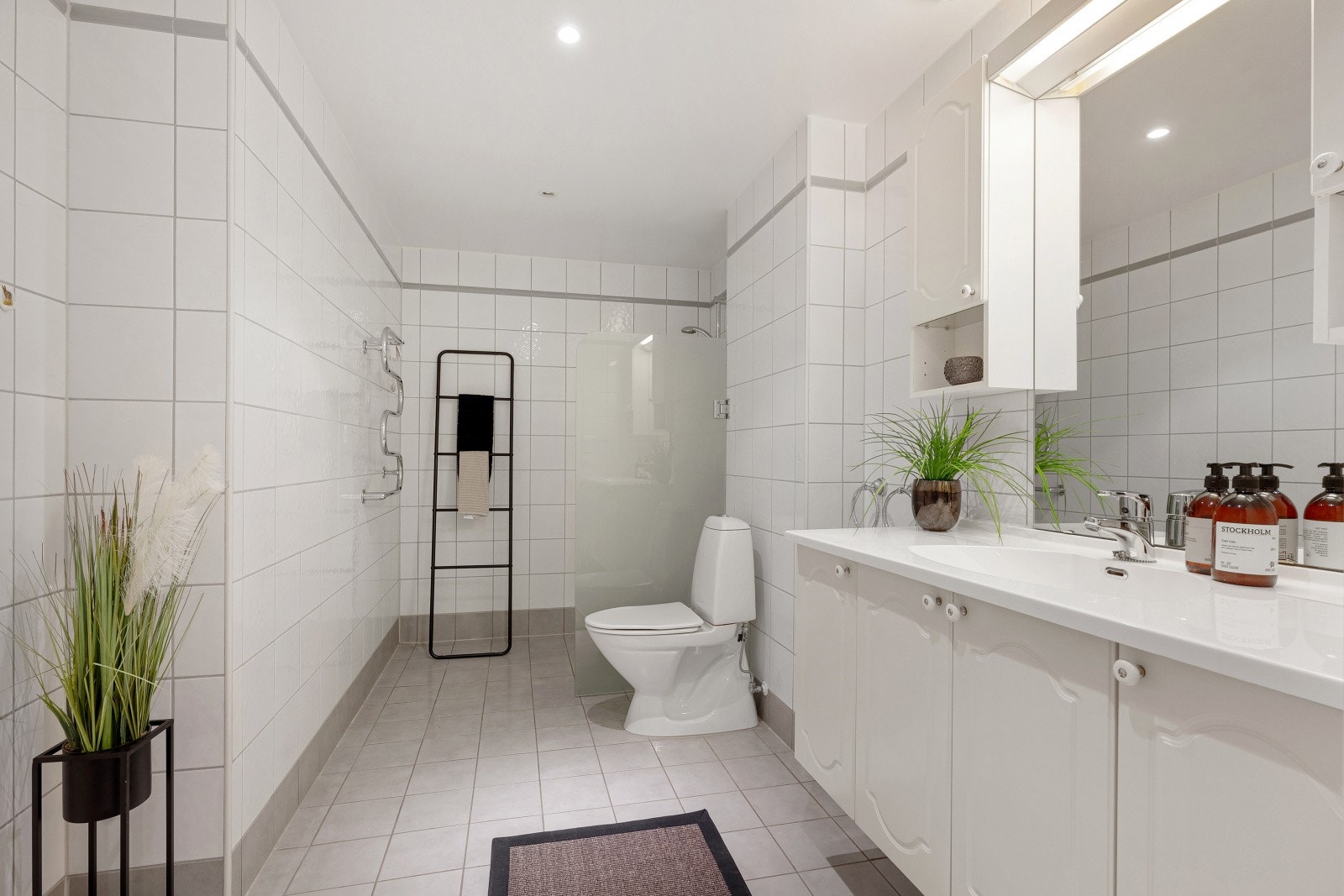 Leiligheten har to bad. Dette er det største, med flislagt gulv og vegger. Galleribilde