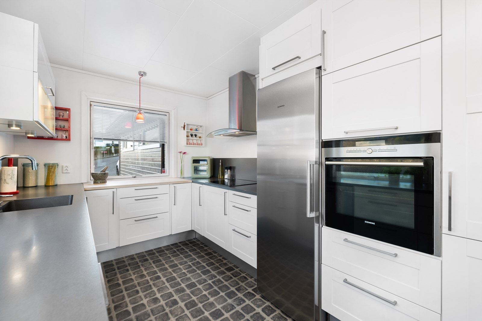 Kjøkkenet er adskilt og funksjonelt utformet, med gode arbeidsflater og praktiske løsninger for matlaging. Galleribilde