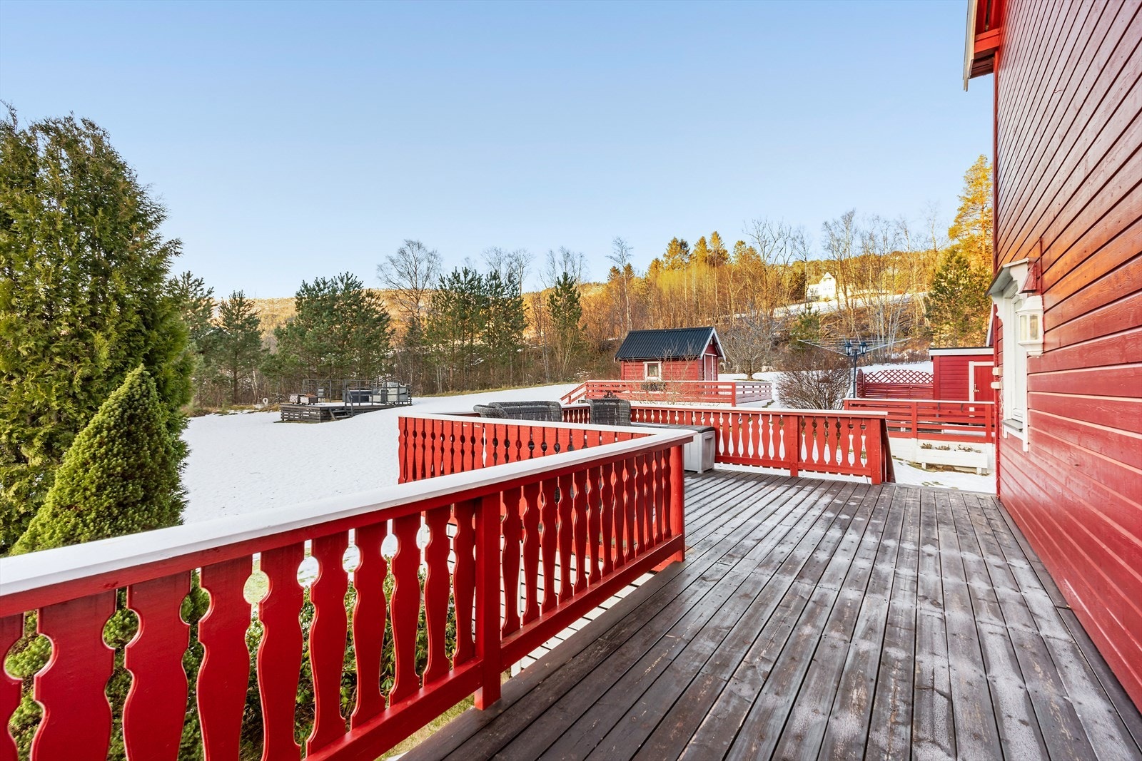 Verandaen er laget av treverk og gir enkel tilgang til hagen og lekestuen. Galleribilde