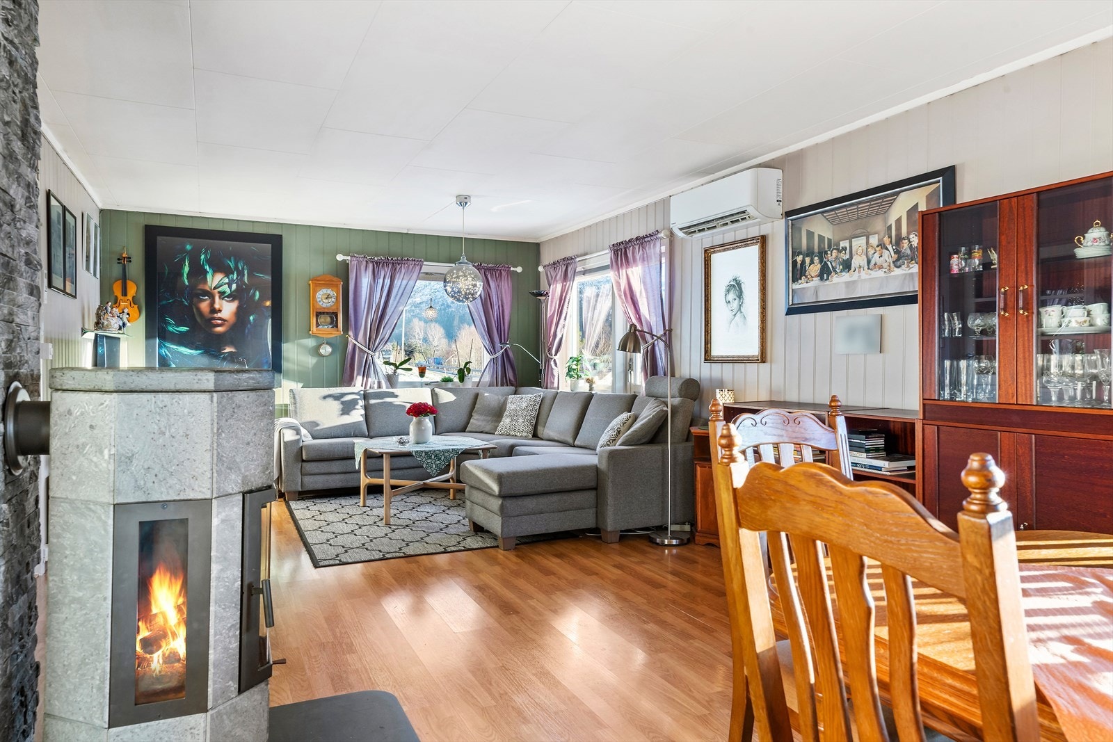 Store vindusflater langs flere av rommets vegger slipper inn naturlig lys i stueområdet. Galleribilde