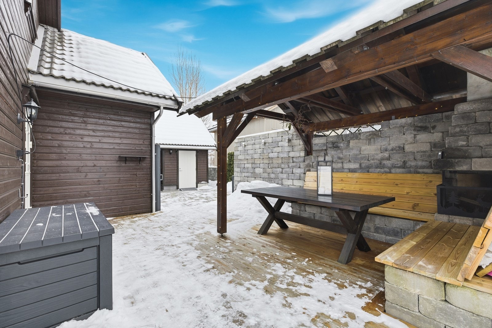 Grillhytta er utstyrt med integrerte benker i tre som gir rikelig med sitteplasser, og en solid bordløsning som inviterer til både måltider og hyggelige sammenkomster med familie og venner. Galleribilde