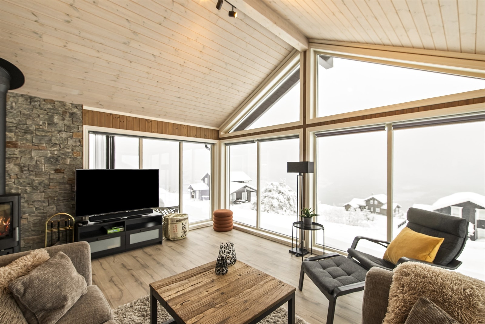 Stuen er lys og koselig med peisovn for kjøligere sesonger Galleribilde