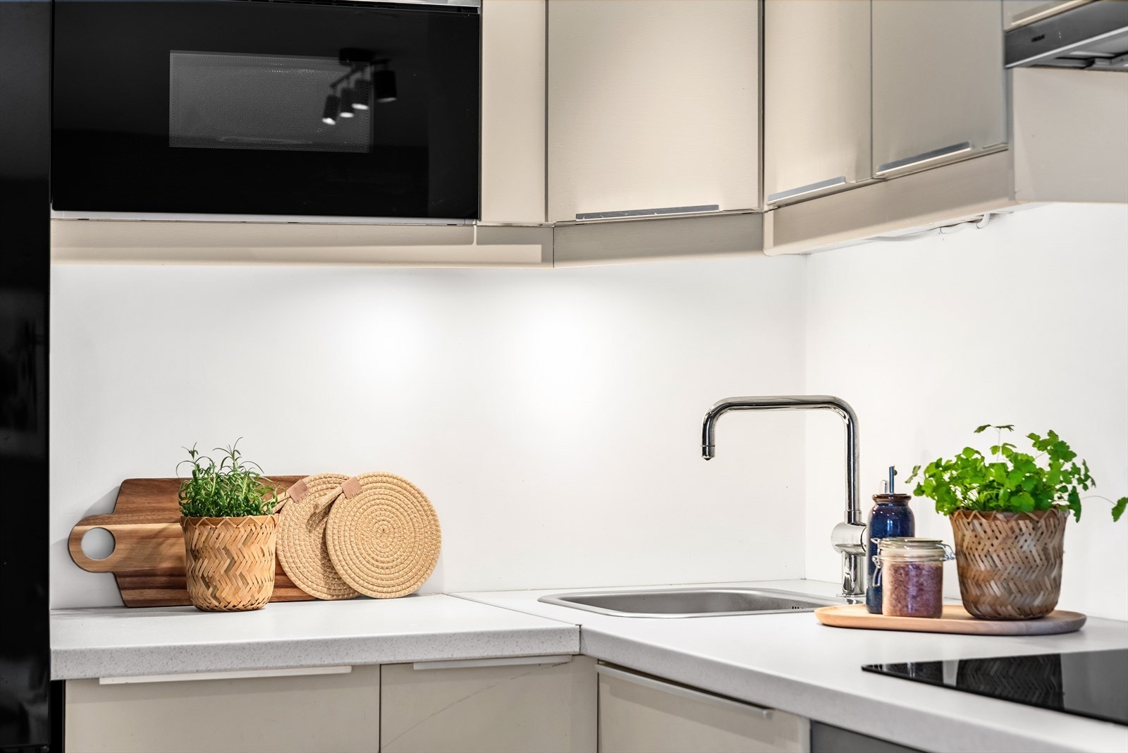 Kjøkkeninnredning med glatte fronter, laminat benkeplate ny i 2023 med nedfelt vask, og belysning under overskap Galleribilde