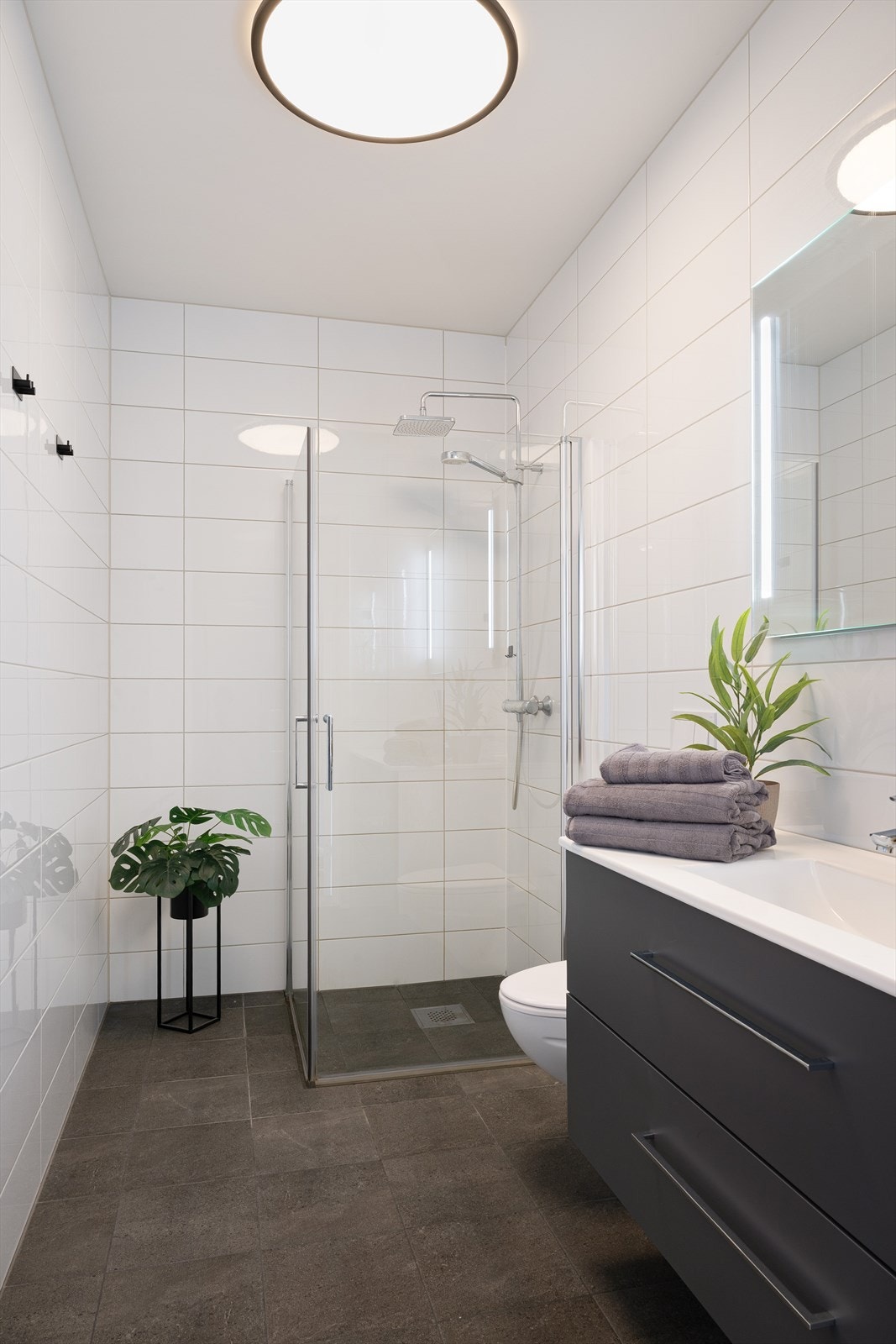 Det inneholder vegghengt toalett, dusj med innfellbare glassdører og servant med underskap. Varmekabler på gulv. Galleribilde