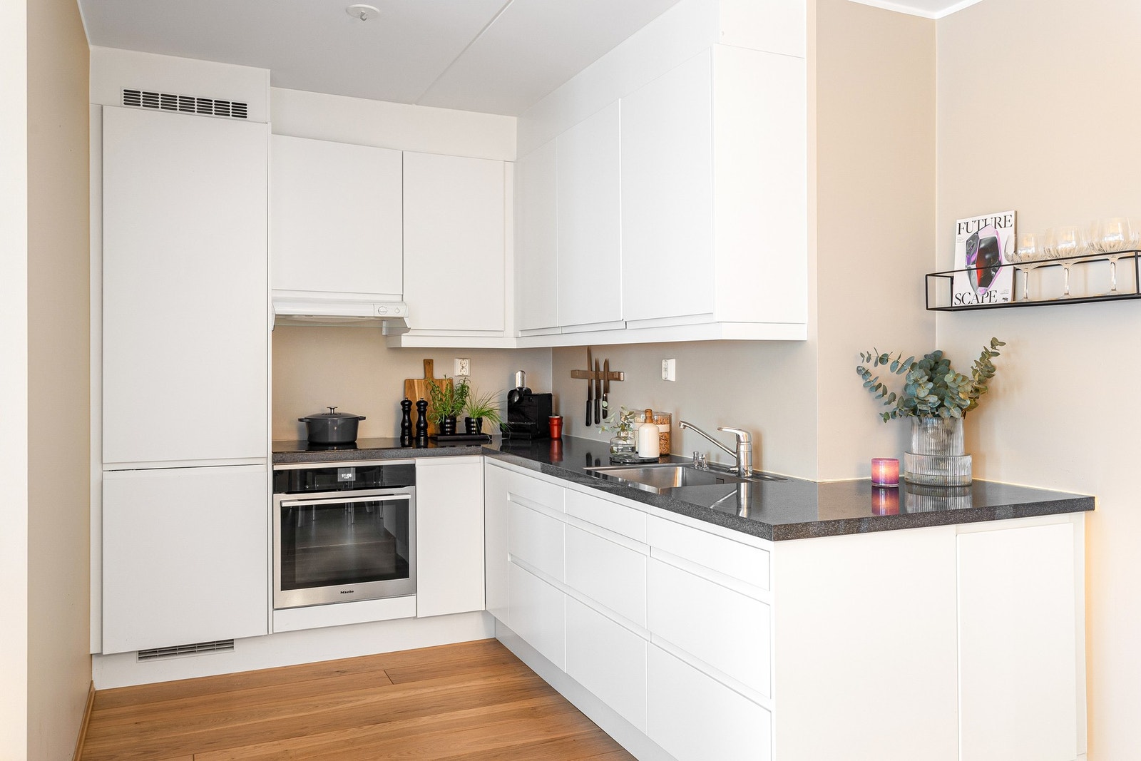 Kjøkkeninnredningen har lyse glatte fronter, laminat benkeplate og nedsenket oppvaskkum med ett-greps armatur. Galleribilde