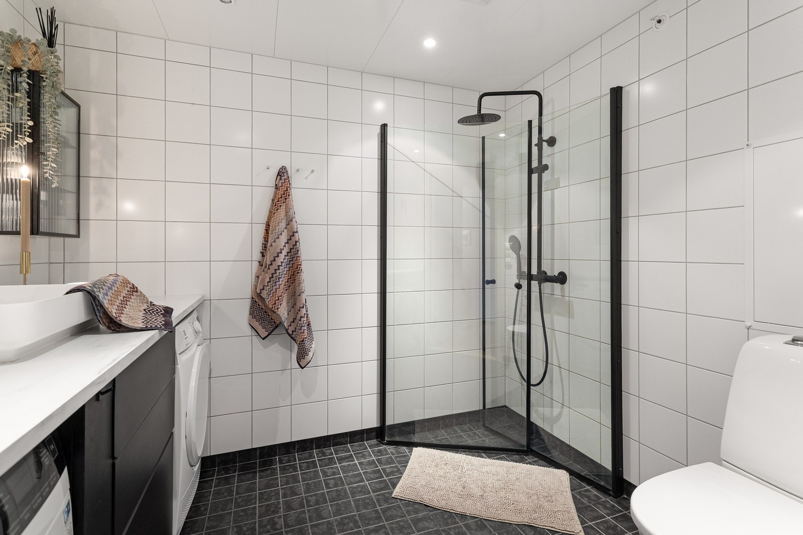 Videre er det vegghengt toalett og dusjhjørne med svingbare glassdører som frigjør plass på gulvet. Galleribilde