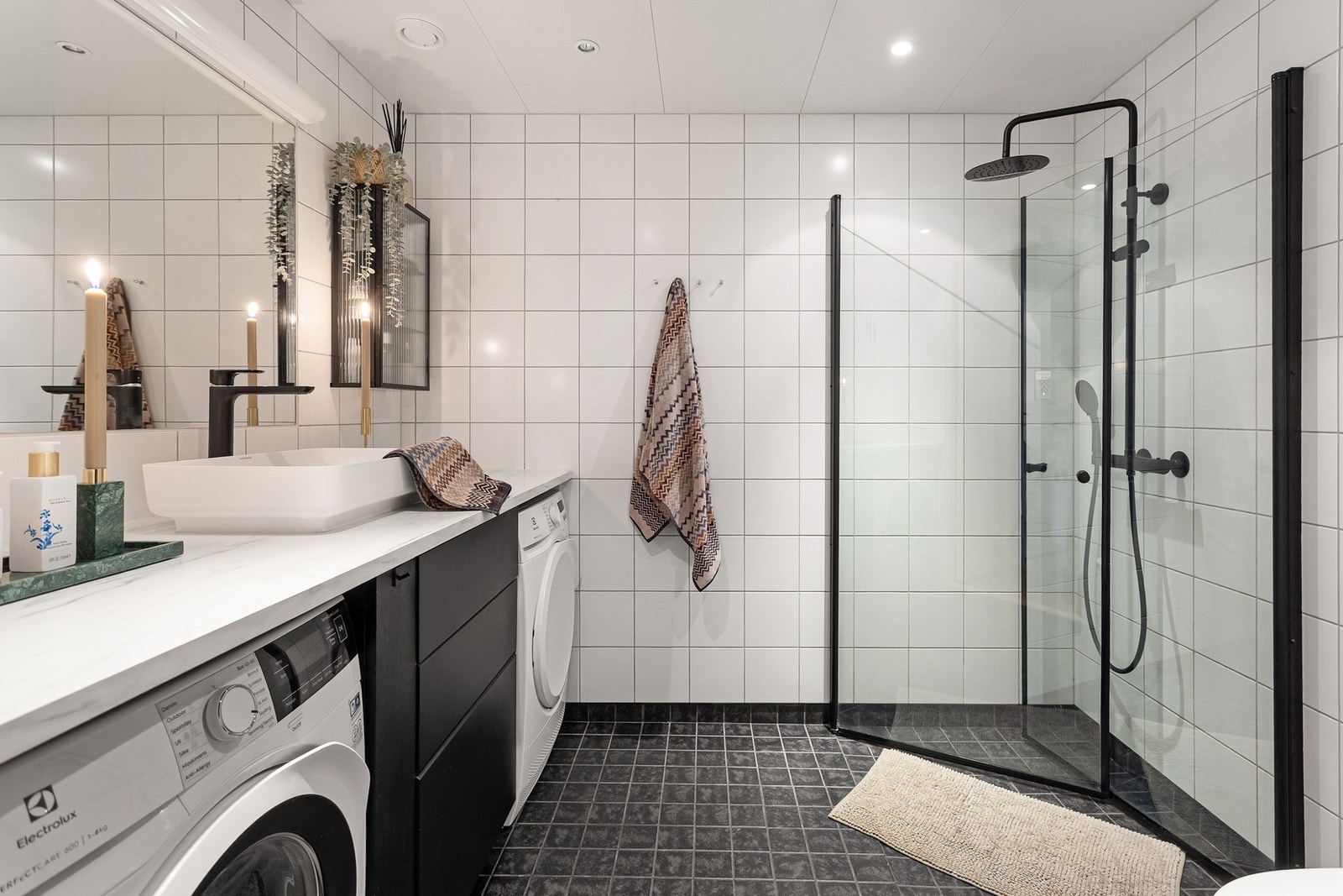 Boligen har et pent flislagt baderom med varme i gulv og downlights i himling. Opplegg for vaskemaskin og plass til tørketrommel under benk. Galleribilde