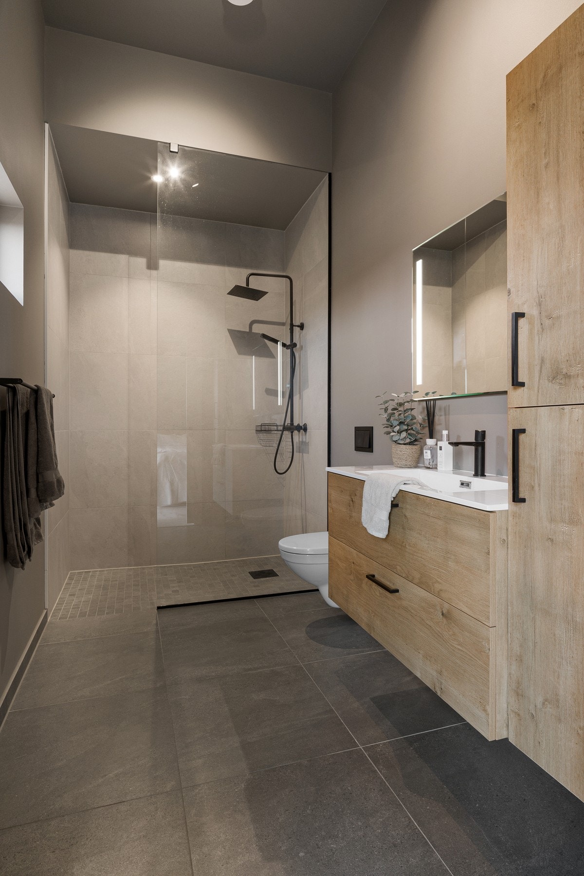 Innredningen består av en praktisk baderomsinnredning med nedfelt servant, høyskap, vegghengt toalett og dusjhjørne. Galleribilde