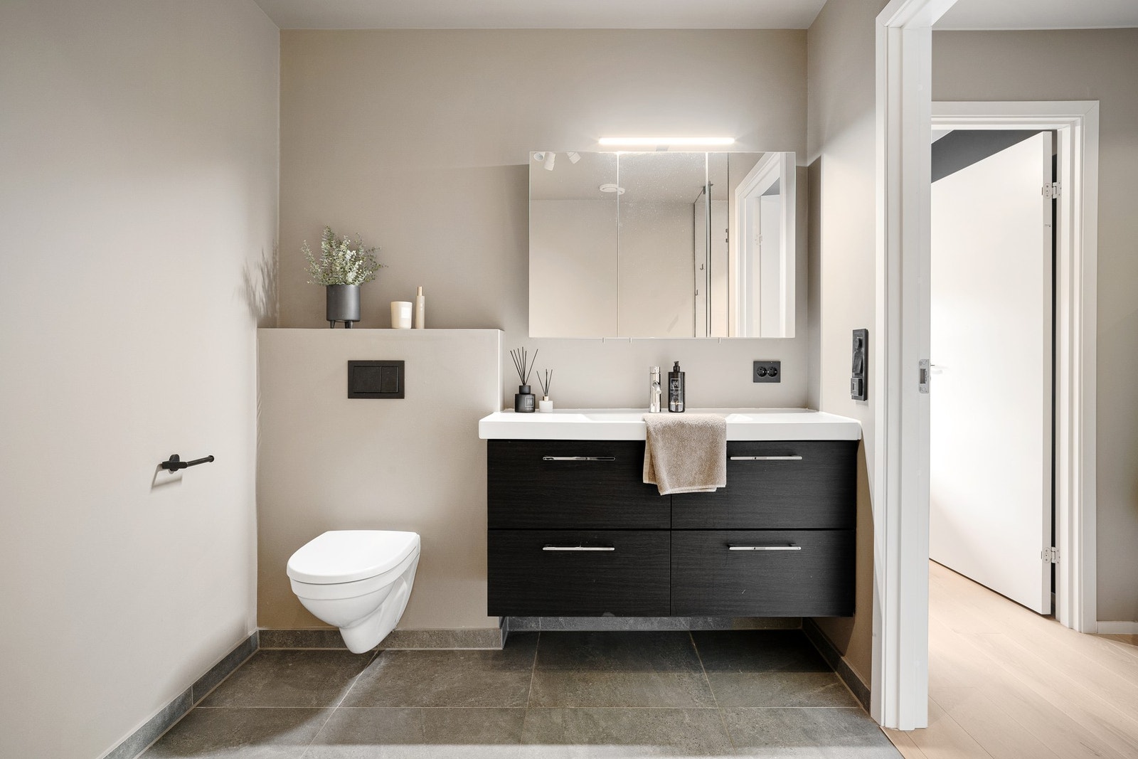 Badet i 1. etasje har flislagte overflater på gulv og vegger i våtsonen. Øvrige veggflater har malte overflater. Galleribilde