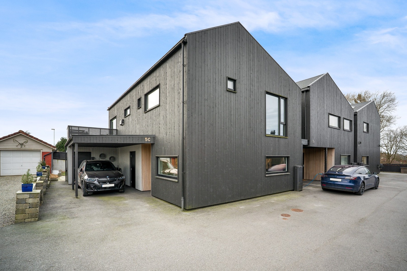 Boligen har parkering i carport med elbillader og tilhørende bod. Galleribilde