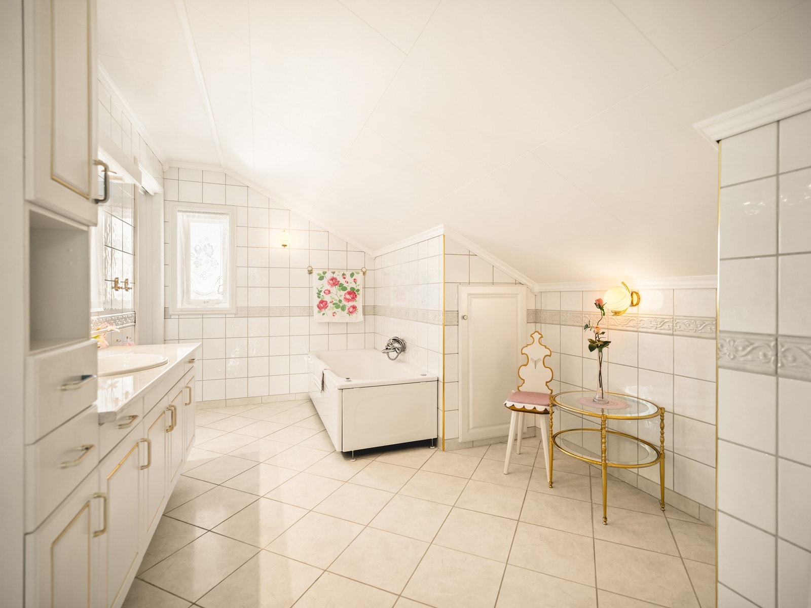 Romslig flislagt bad med badekar, servant og wc. Galleribilde