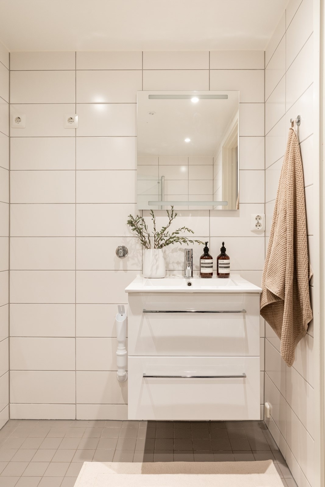 Badet er innredet med vegghengt klosett, servant med innredning og speil med lys. Det er opplegg for vaskemaskin. Galleribilde